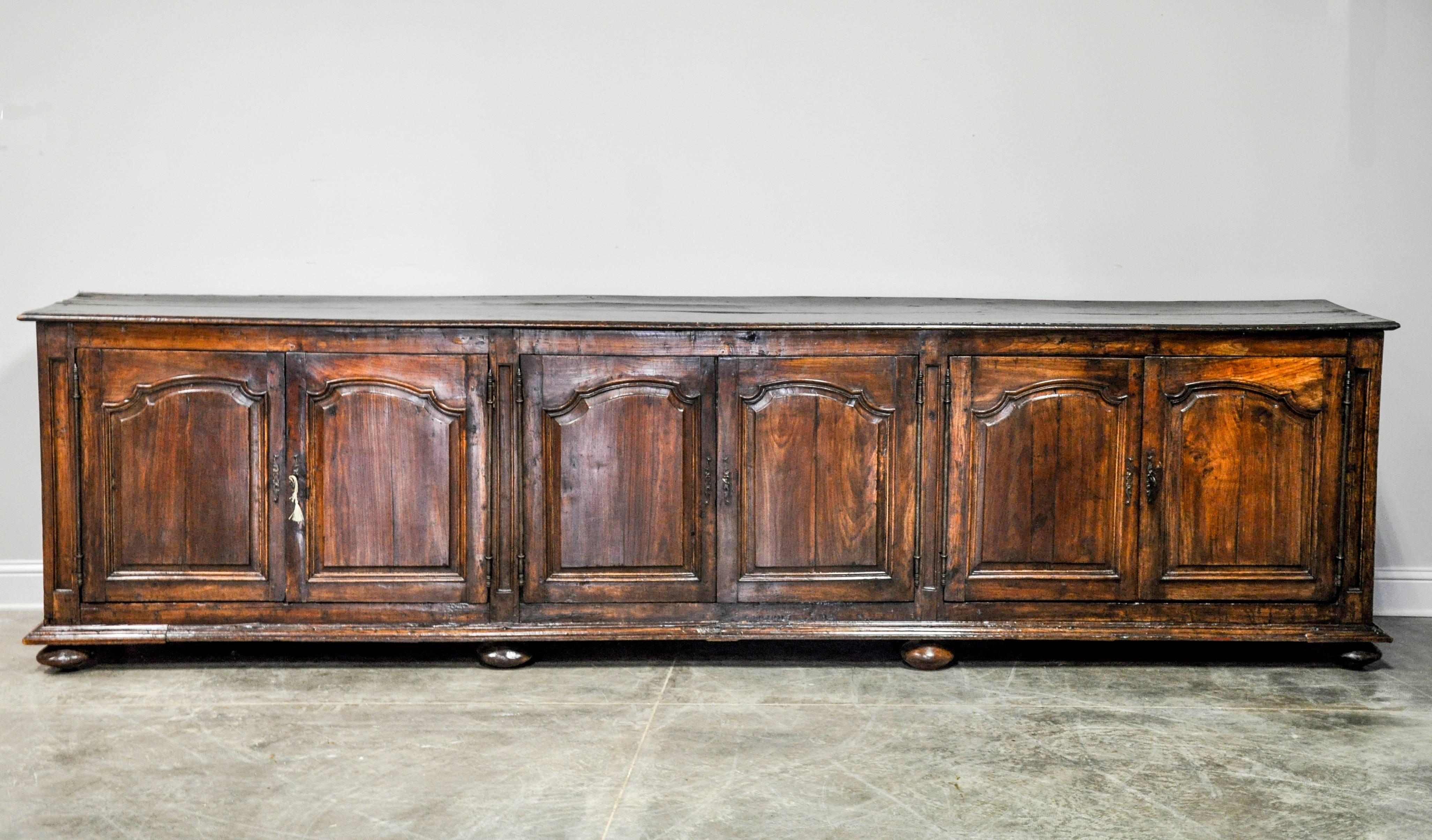 Remarkable 19th century Louis XIII transitional Louis XIV style enfilade in walnut. Six doors open to three large cabinets each with a single, original shelf complete. Original backing and hardware with lock and key mechanism completes this