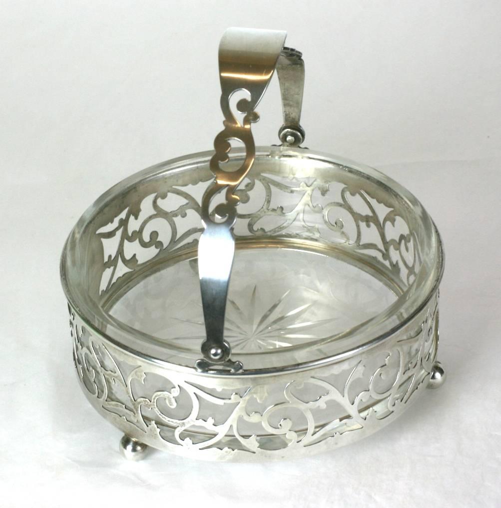 Sterling handled candy dish with glass liner. Pierced scrollwork gallery and handle with ball feet, 1950s, USA.
Excellent condition.