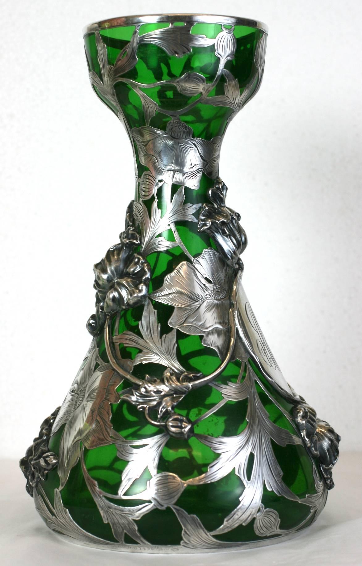 Exceptionally rare silver overlay vase by Alvin Mfg Co. of Providence Rhode Island from the late 19th century. 
This vase is a tour de force of Art Nouveau silver work on glass. The intricate sterling floral base design is overlaid onto the emerald