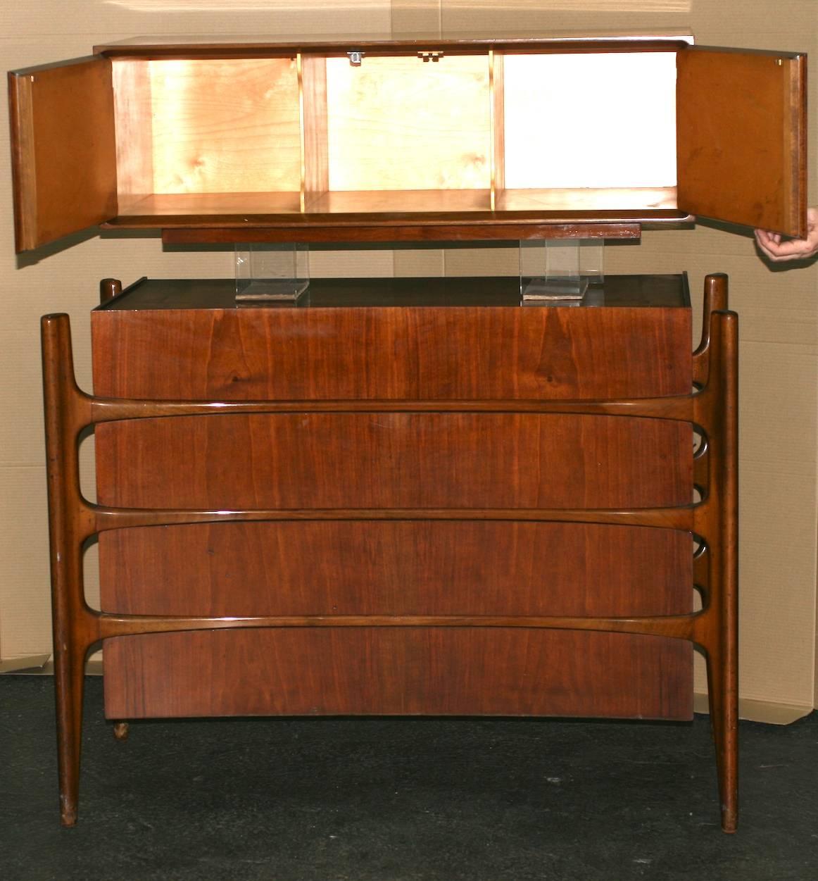 Cool, sculptural Swedish walnut four-drawer dresser with wall mount cabinet (three compartments) by William Hinn.
Amazing design with the curved dresser extending into pegged legs which protrude like organic struts supporting the drawers.