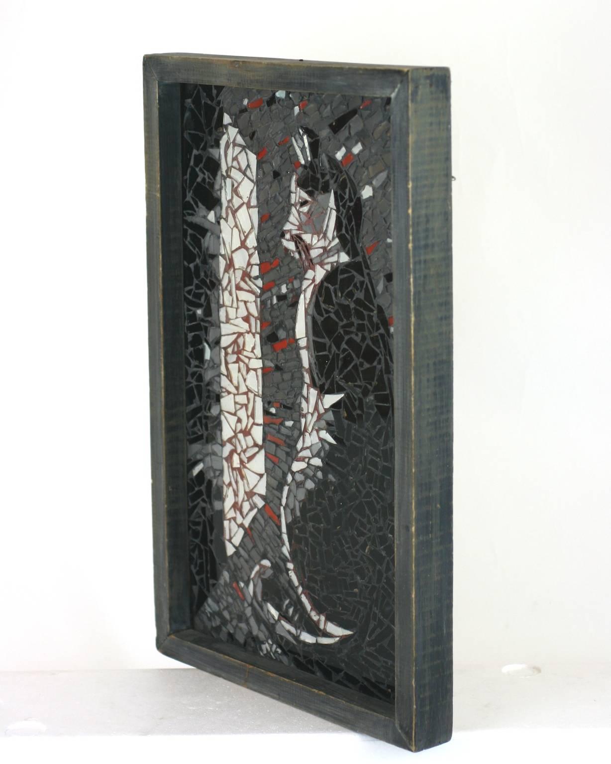 Charming Folk Art glass shard cat picture set within a grey washed handmade wood frame. Made with glass shard mosaics by hand depicting in an image of a cat peering out a window in striking shades of black, white and red.
1940s, USA. 
Measures: