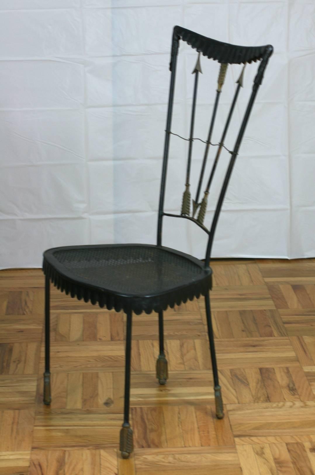 Surrealist iron garden chair with arrow motifs by Tomaso Buzzi. Brass arrow points and feather motifs contrast with the blackened iron. Draped metal 