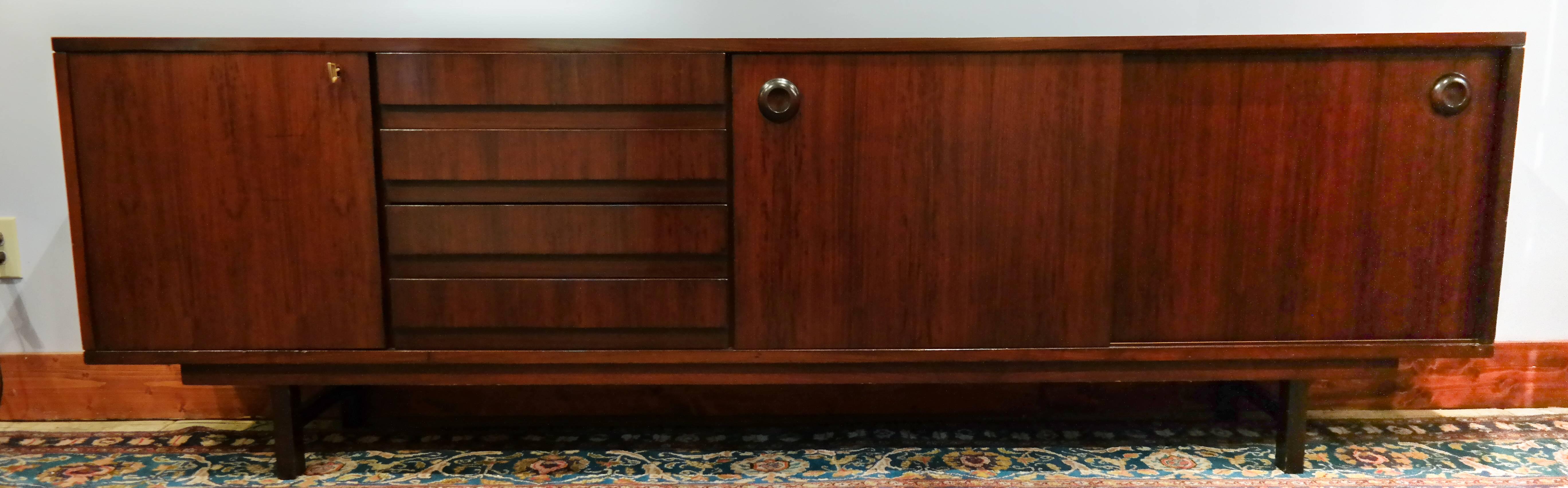 Mid-Century Modern, rosewood sideboard, single door cabinet to the left beside four drawers, with two sliding doors to the right, supported by block legs, Italian, circa 1960.