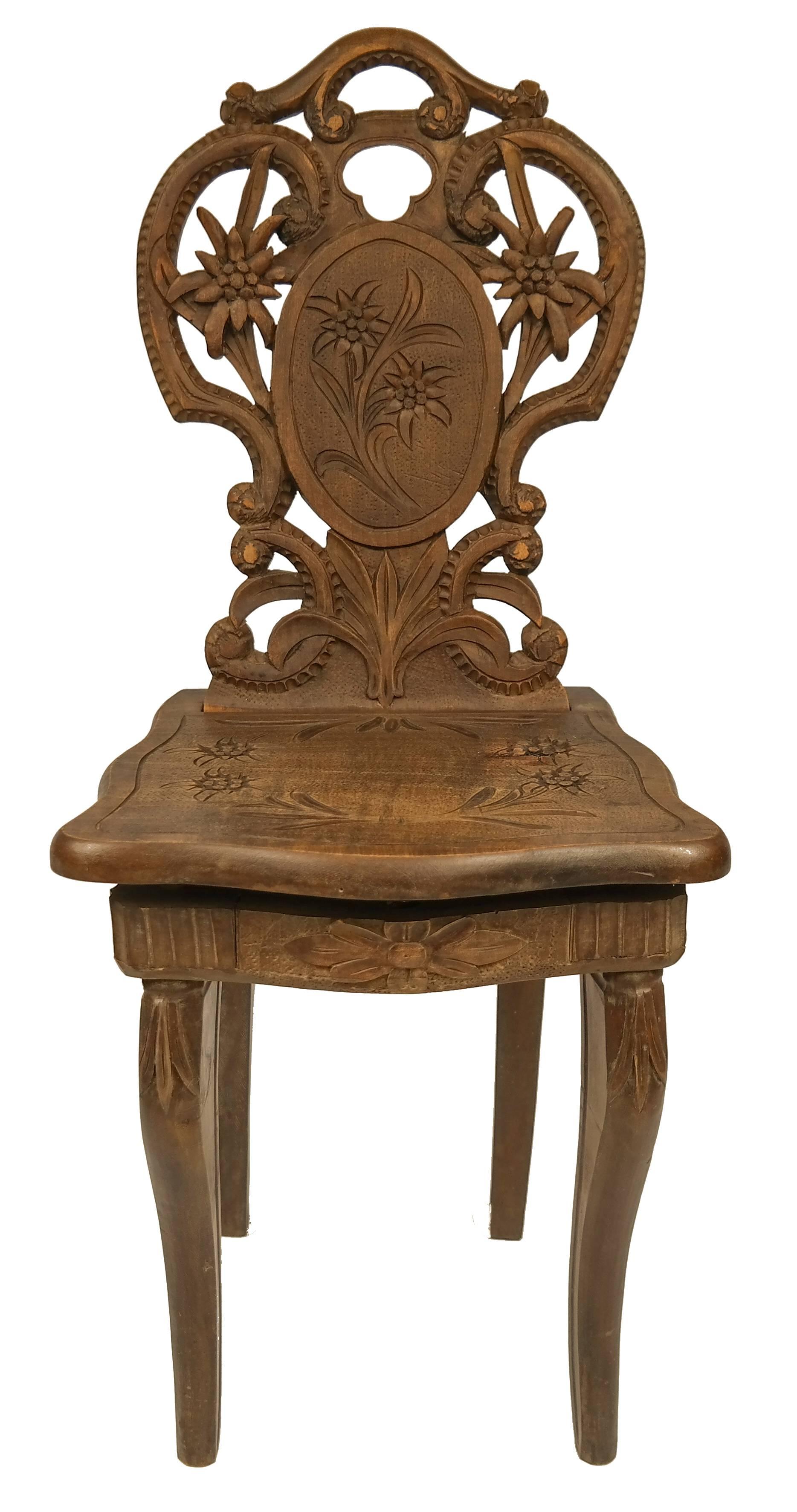 Rare 1890's Swiss walnut black forest musical chair with hand carved edelweiss. A functional music box is located under the seat and plays when the seat is being used.
