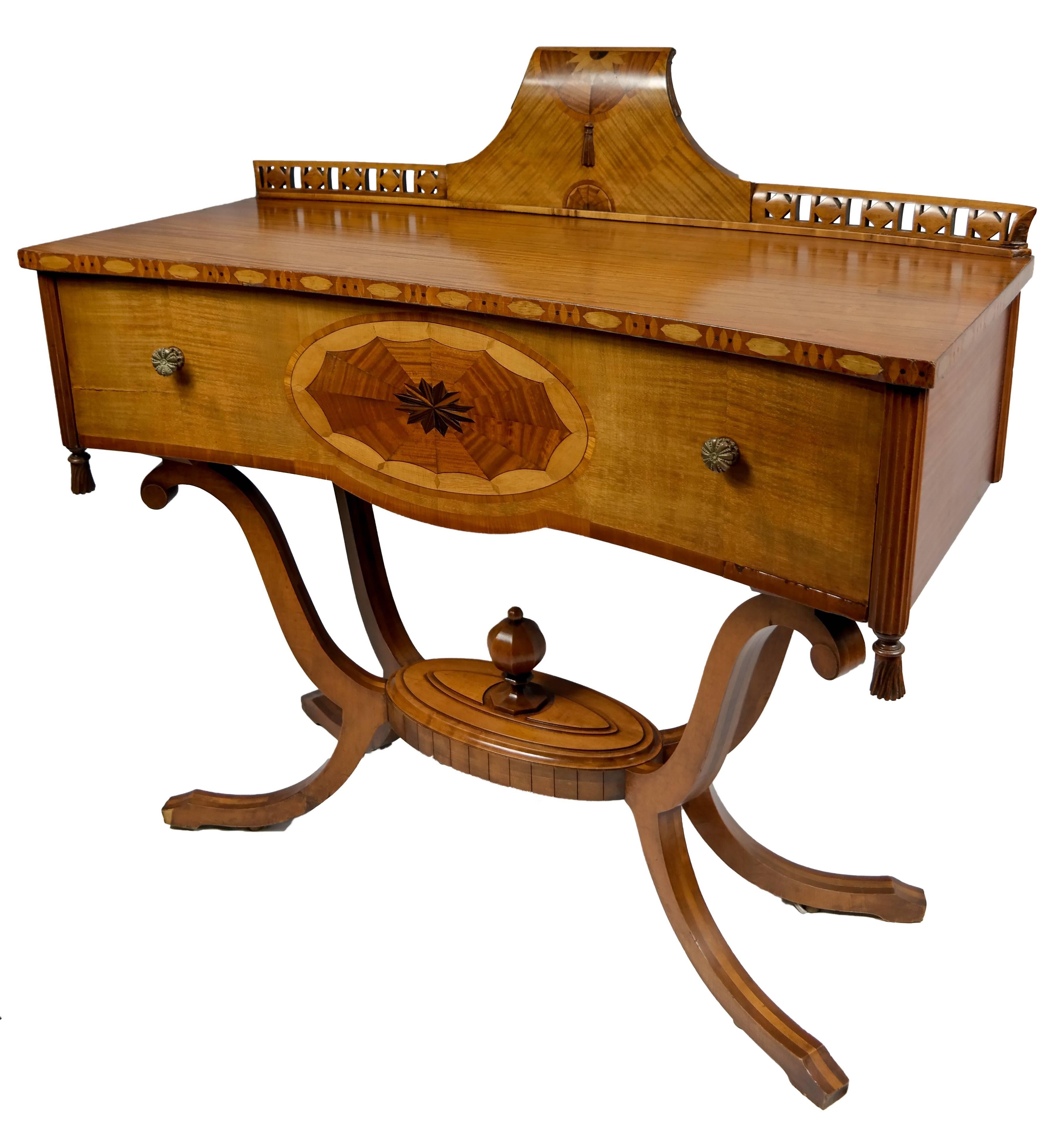 Satin Mahogany server with tiger maple drawer, below a reticulated and inlaid back splash, on inlaid feet, American, mid 20th century.
