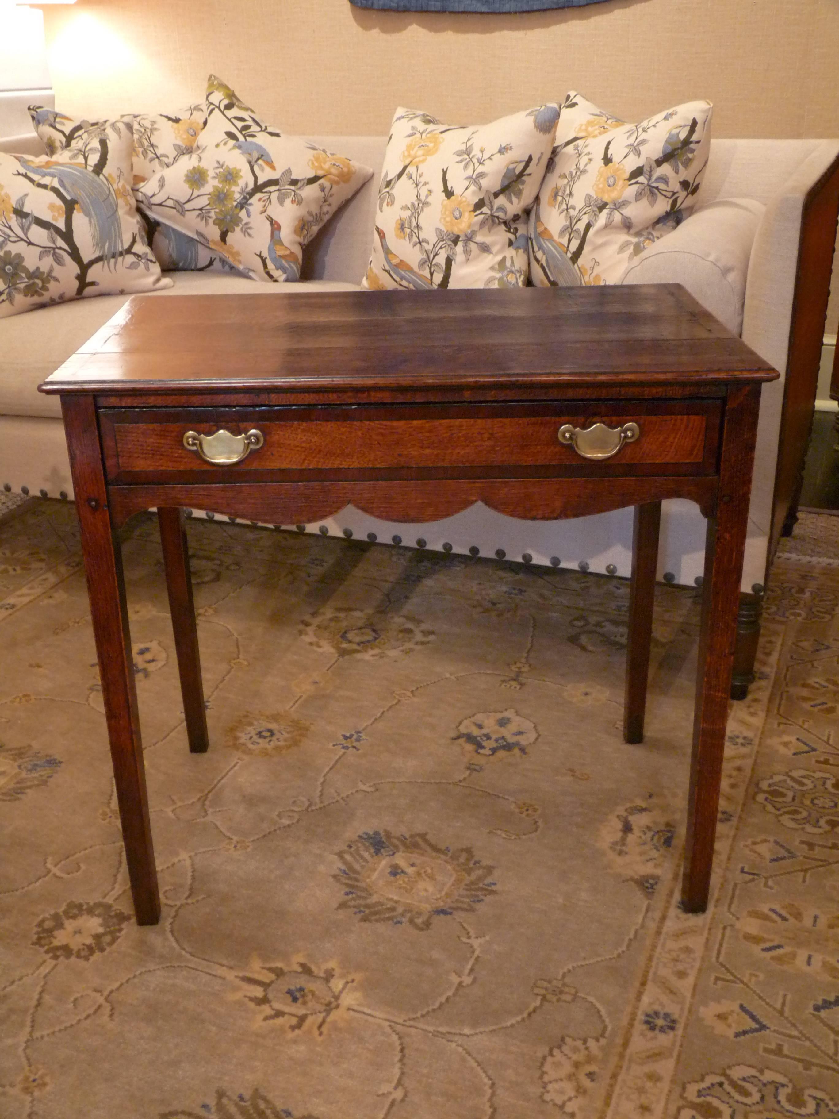  A very clean and elegant example of a fine English Georgian hall table. A single drawer, original brass hardware and a scalloped apron front. Beautiful patina.