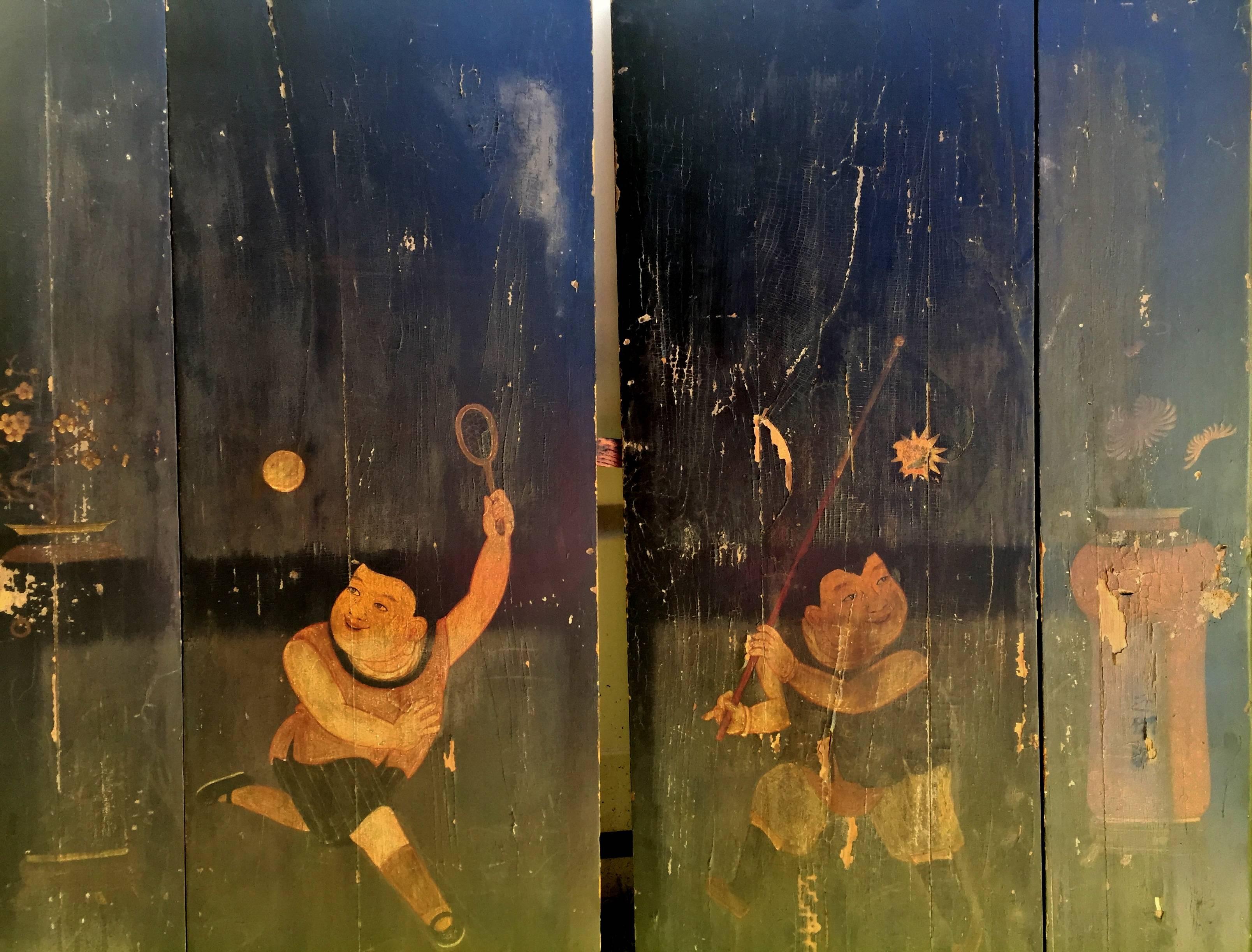 This wonderful pair of door is very special. Shorter and wider, they were made specially for the young sons of the family. Hand painted images of boys playing a ball game express great pride and happiness. The boy's outfits and the game they are