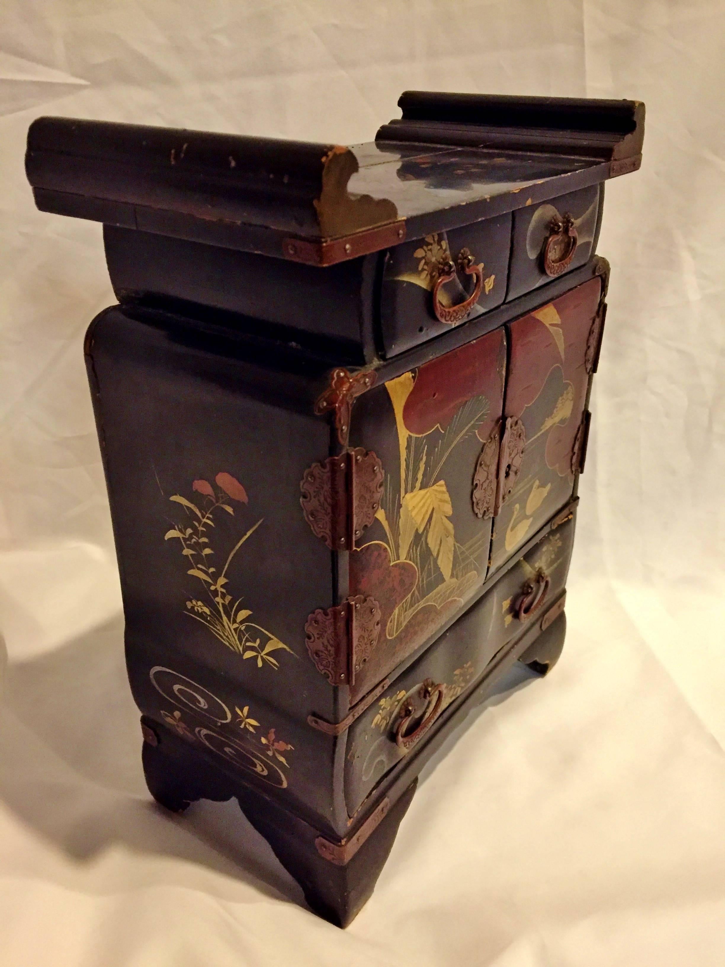 This stunning jewelry box is a jewel itself. Finished in Japanese lacquer, a process that is extremely time consuming and painstaking, this box depicts hand-painted love birds swimming in a lake surrounded by palm trees and birds flying in the sky