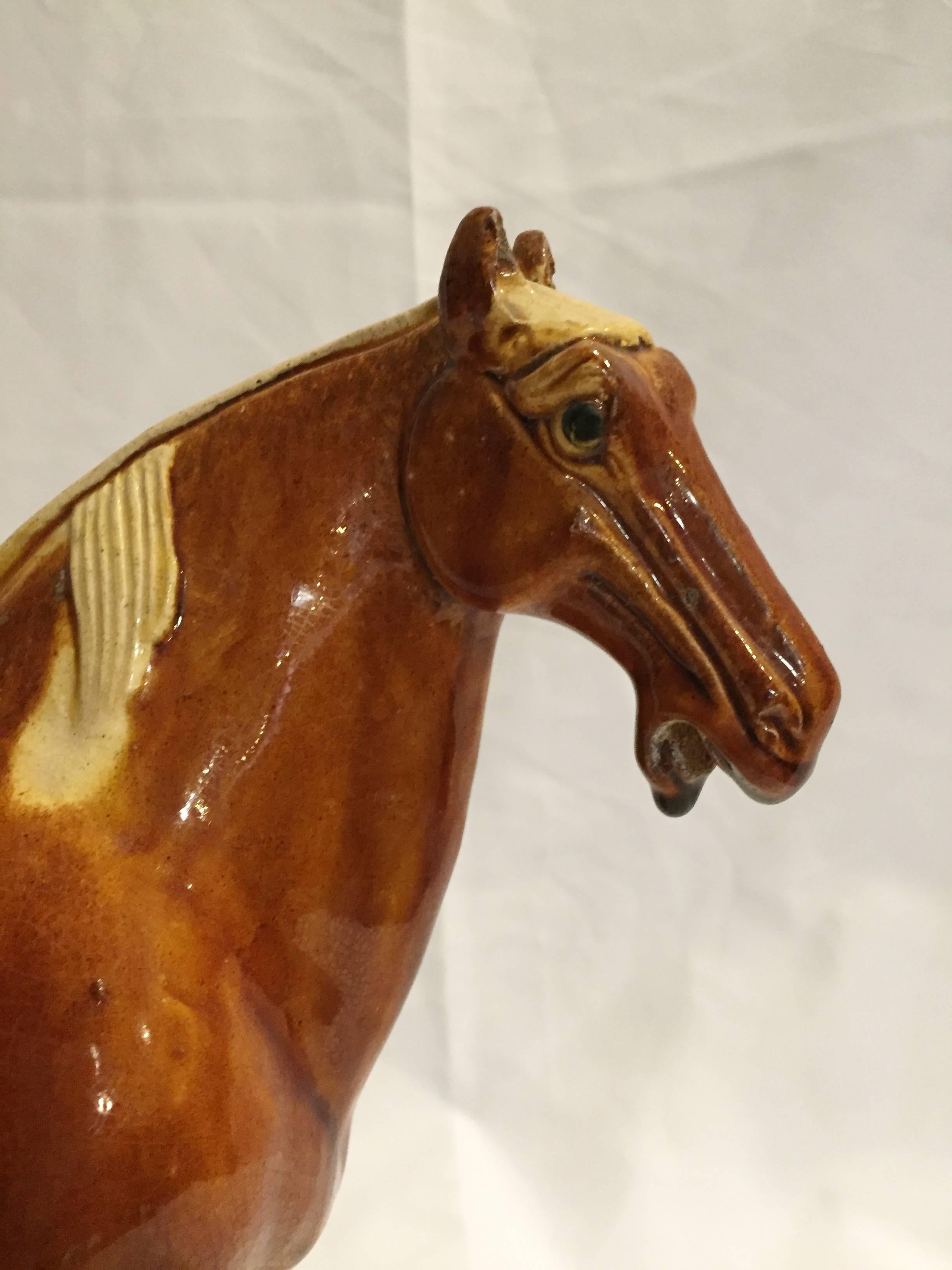 This pair of beautiful terracotta horses are handmade and painted using the ancient Tri-Glaze techniques. A true work of art, the splendid glossy glaze is distinctive of Tang San Cai style. Glaze is skillfully applied achieving high artistic effect.