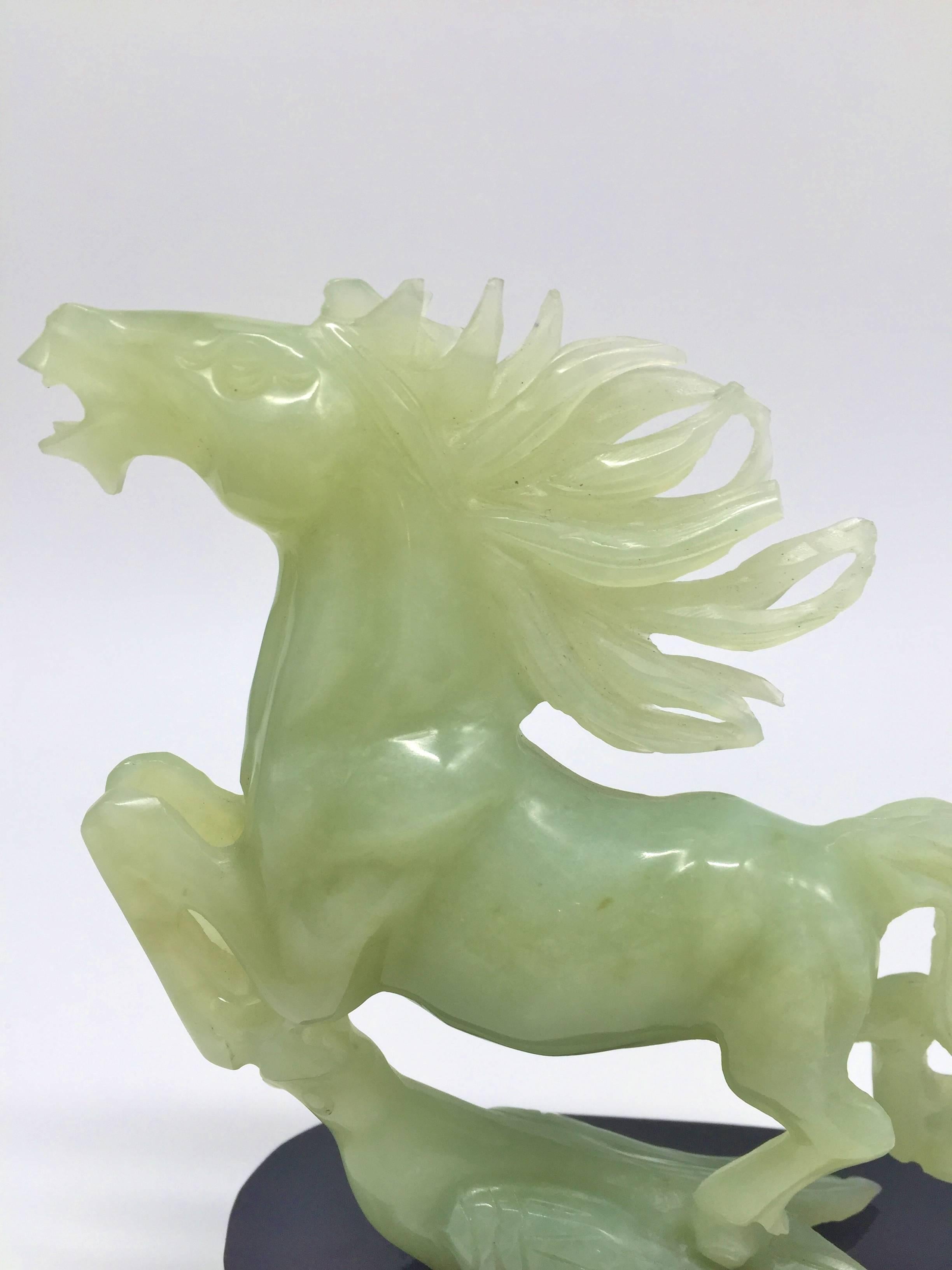 A beautiful sculpture of jade horse with one of his hoofs on a swallow, a symbol of superior speed and success. A boulder of fine celadon jade became an art piece through the hands of a master carver. This majestic horse is caught in motion of