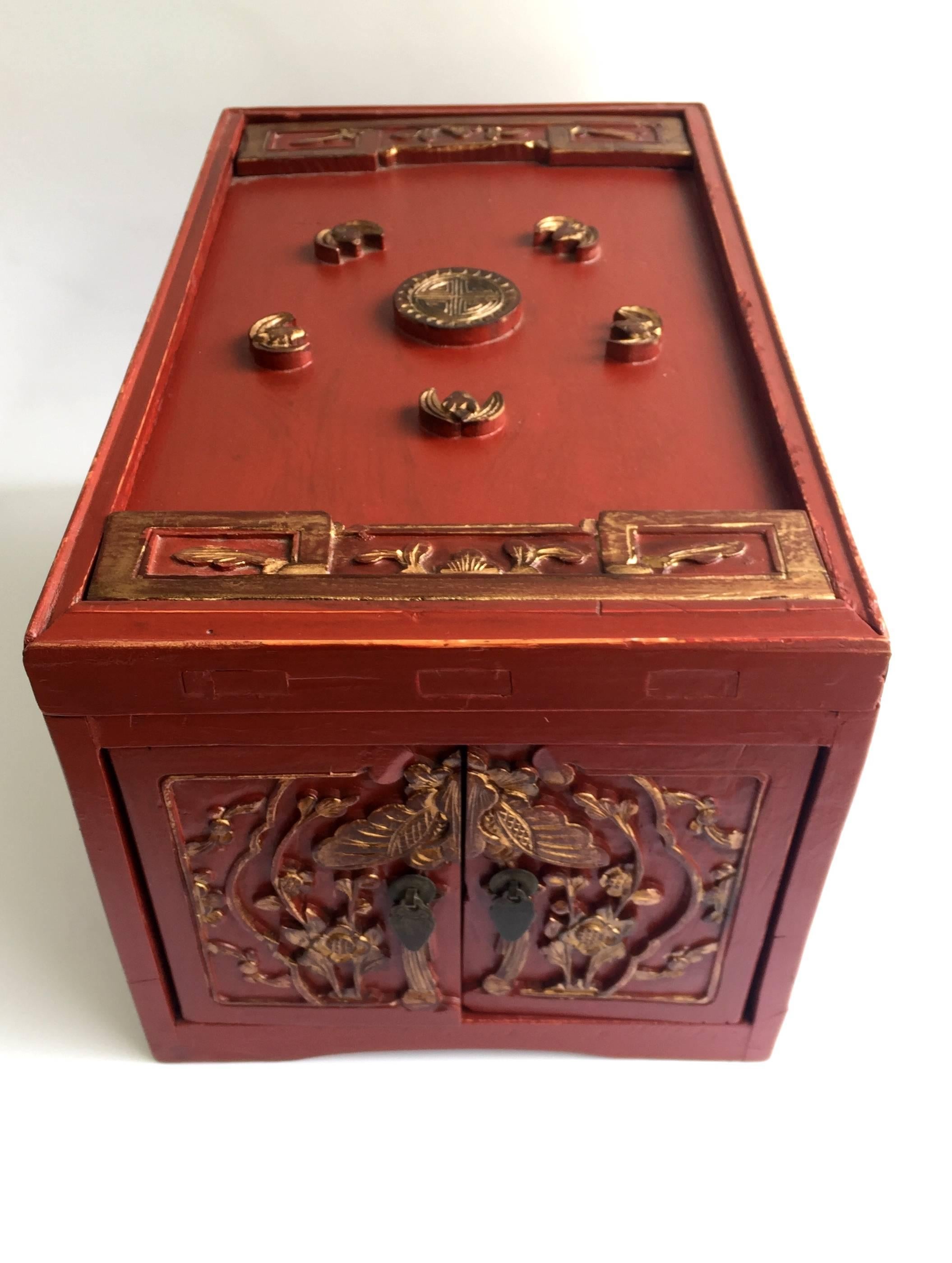 Beautiful red lacquer jewelry box features two very long, full length drawers. Top carved panel is removable for additional storage and display of jewelleries. Carved flowers symbolize beauty and strength. Butterfly over the doors means love and