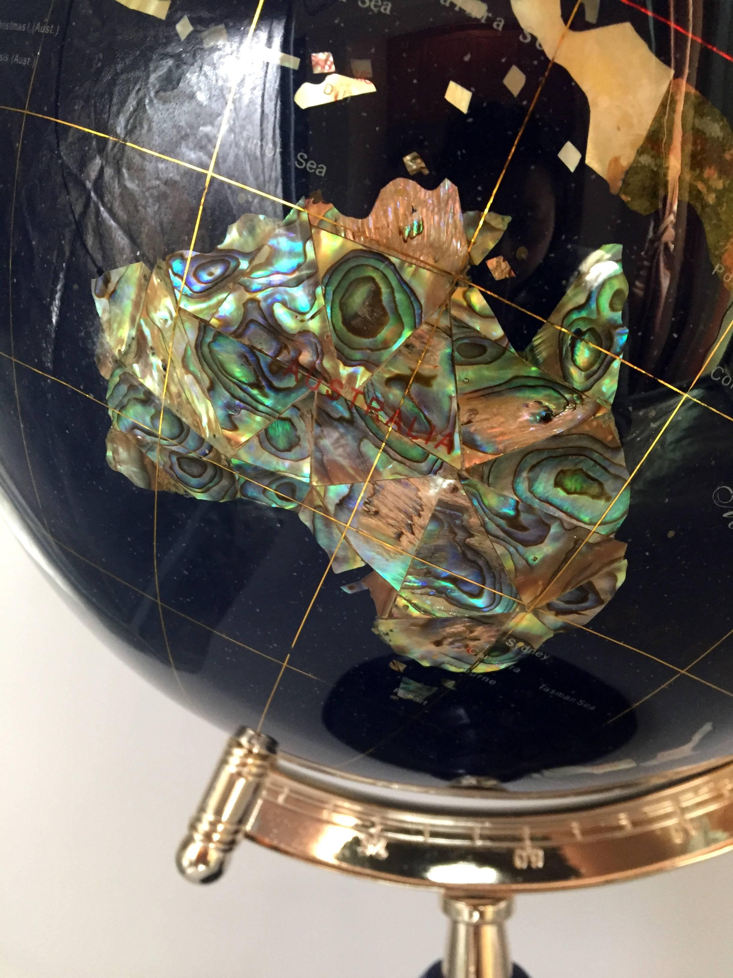 This spectacular globe is made with all genuine gem stones. The base is ground lapis, with jasper, mother-of-pearl, agate, sandstone and many other gem and minerals shaped into the shape of countries, hand fitted and polished to perfection. The