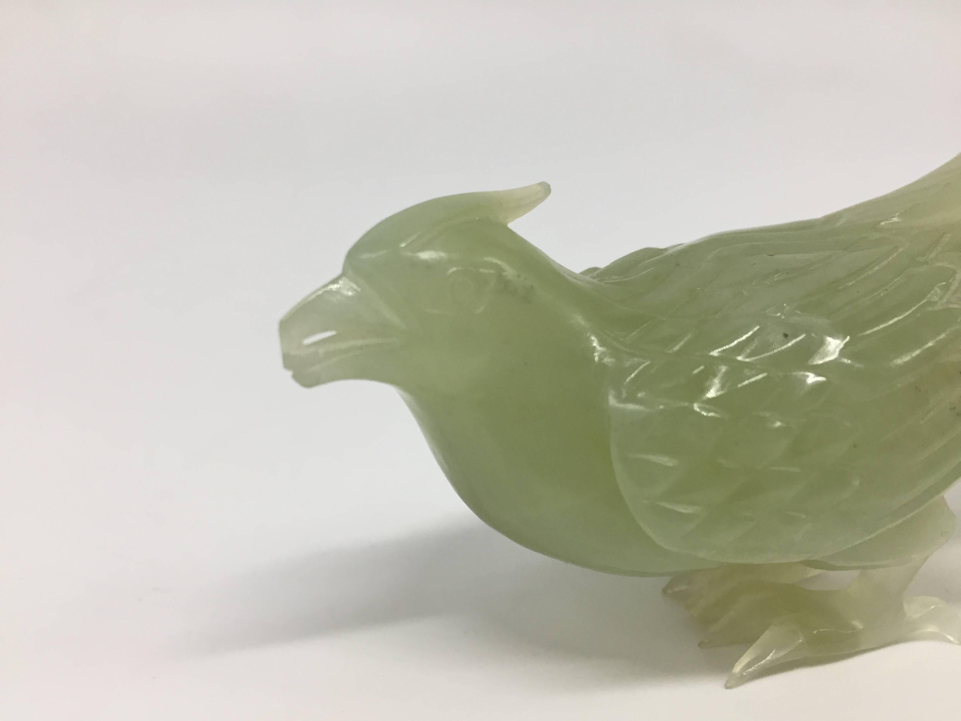 Exquisite peasant is carved from a block of all natural green Xiu Yu, in China regarded as a type of jade. The bird's feathers, beak and claws are very finely done. Its expression is vivid and lively. 

Peasant in the Chinese culture is regarded as