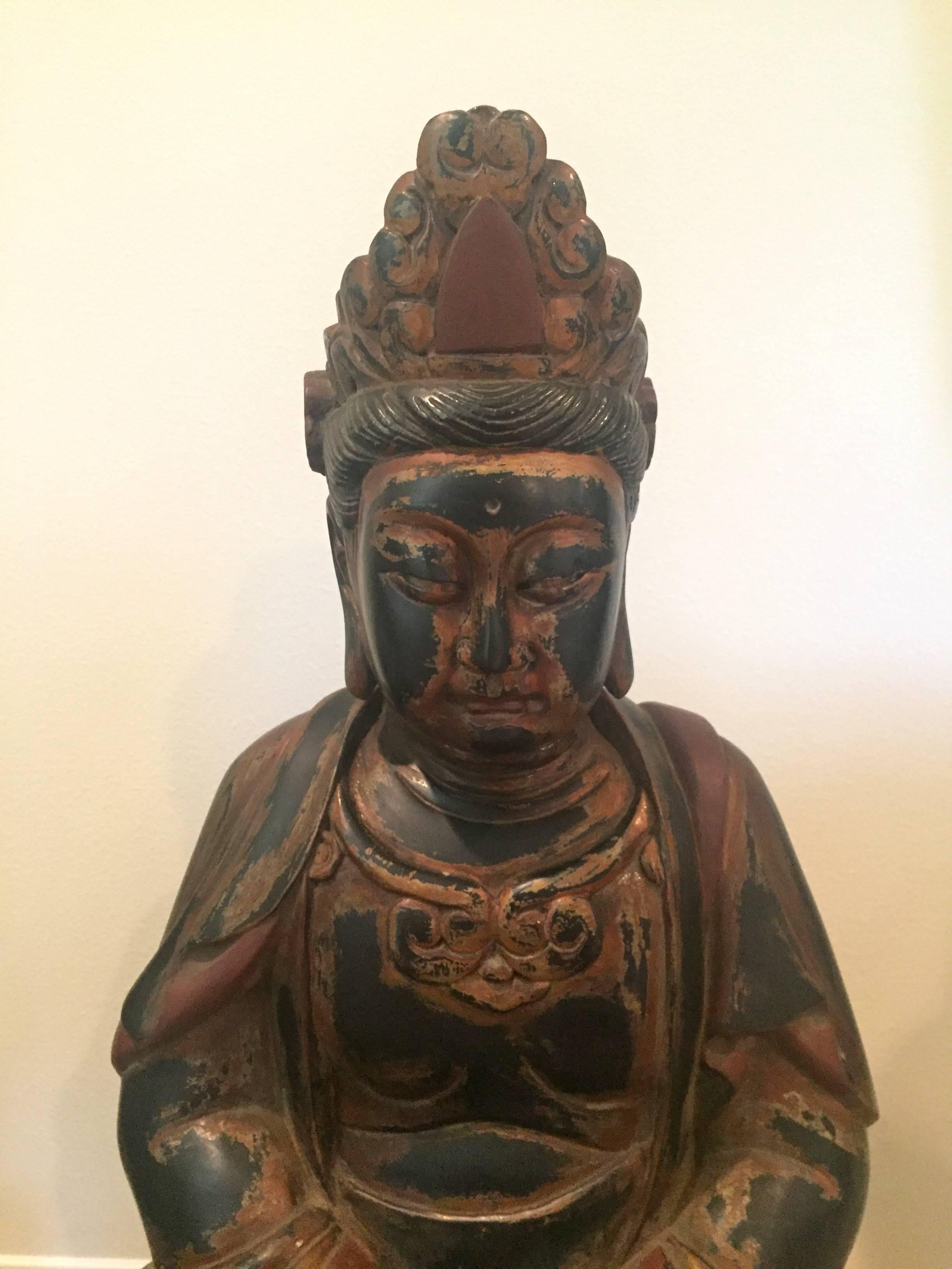 Stunning Buddha statue is made of solid wood. He is seated on a carved lotus throne, his hands in the mudra of unity. The facial expression is serene and peaceful. The style of Buddha follows the Traditional Design of the Tang dynasty, with a full