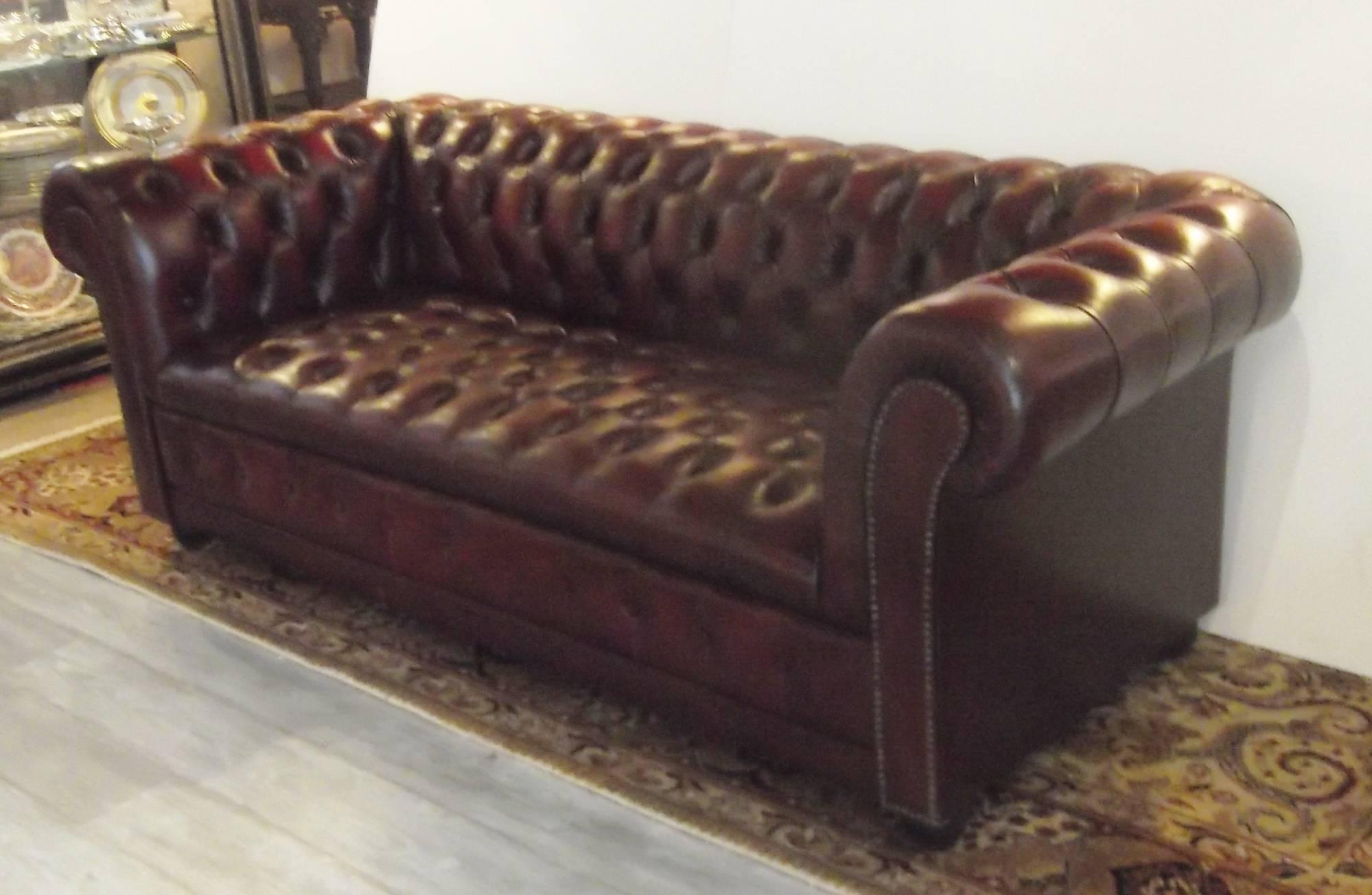A Classic button tufted Chesterfield sofa with nailhead trim.
Cordovan leather with a slight worn finish, no rips or tears, all buttons neatly in place. 76
