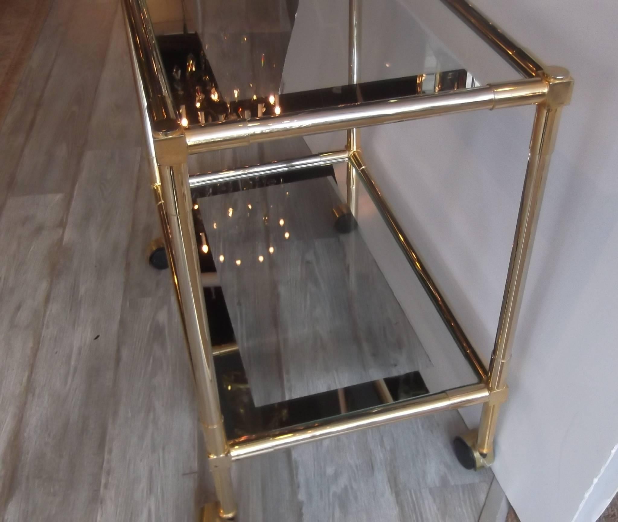 Very stylish brass-plated steel bar cart. Two-tiered with shelves trimmed with a 1.5