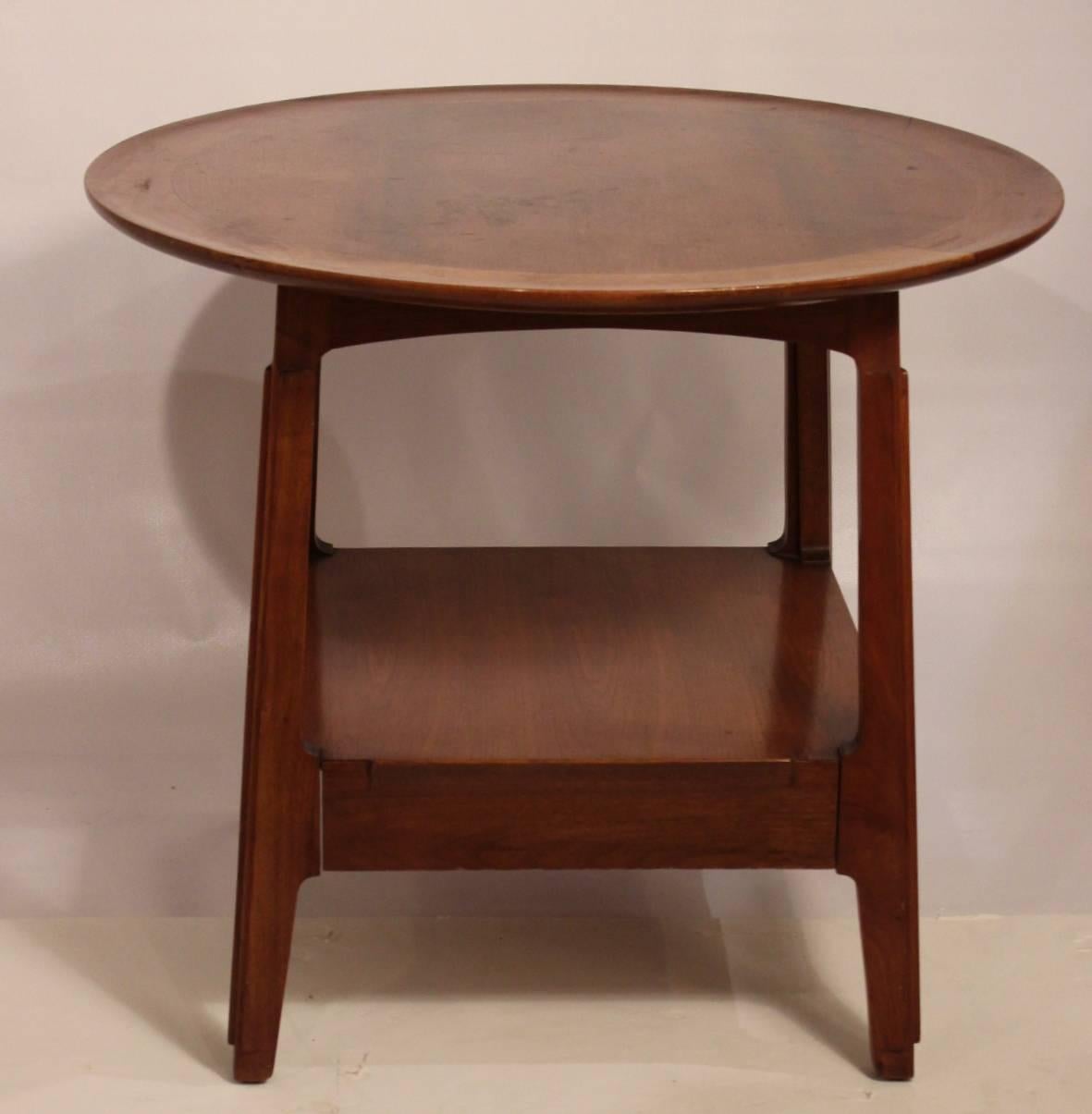 A pair of authentic Dunbar walnut dish top tables. They are slightly deeper than wide, with well-proportioned  tops. These table have well-designed bases with four slightly splayed legs with discreet carved lines with a cleverly hidden lower drawer,