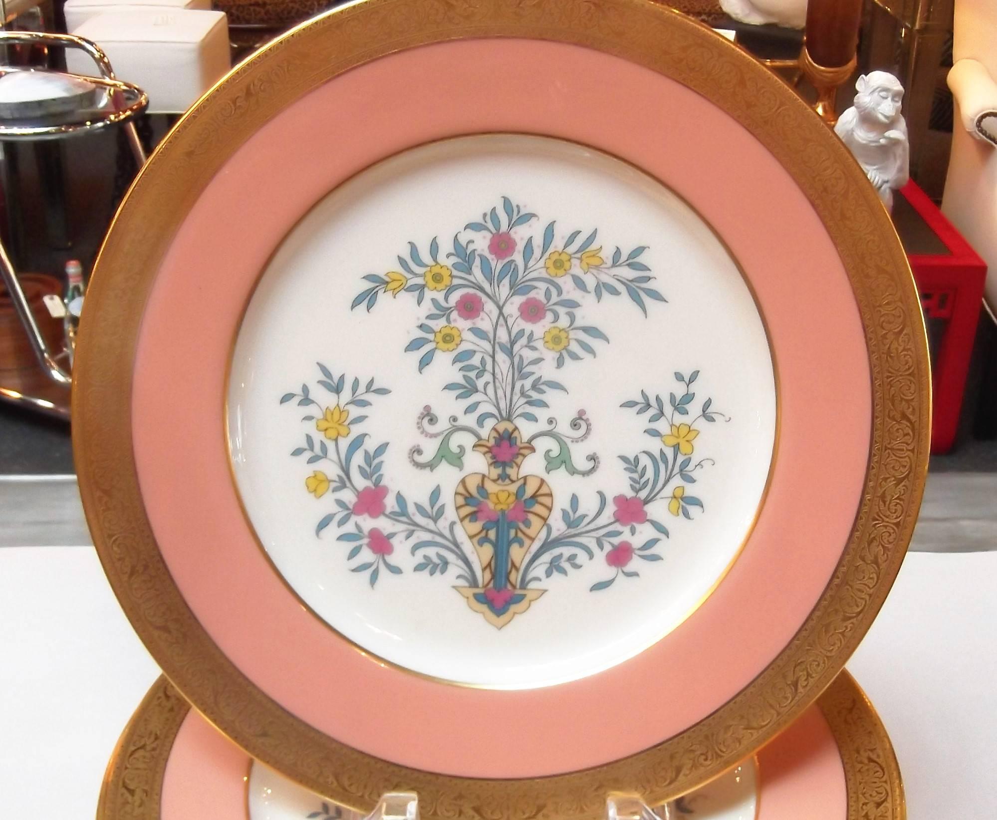 A set of 12 gilt and enamel decorated service plates. The brad band gold border with a salmon border centered with and stylized vase of floral and vine.
This set was first introduced in 1927 by Lenox, and was a custom order. The set has a year mark