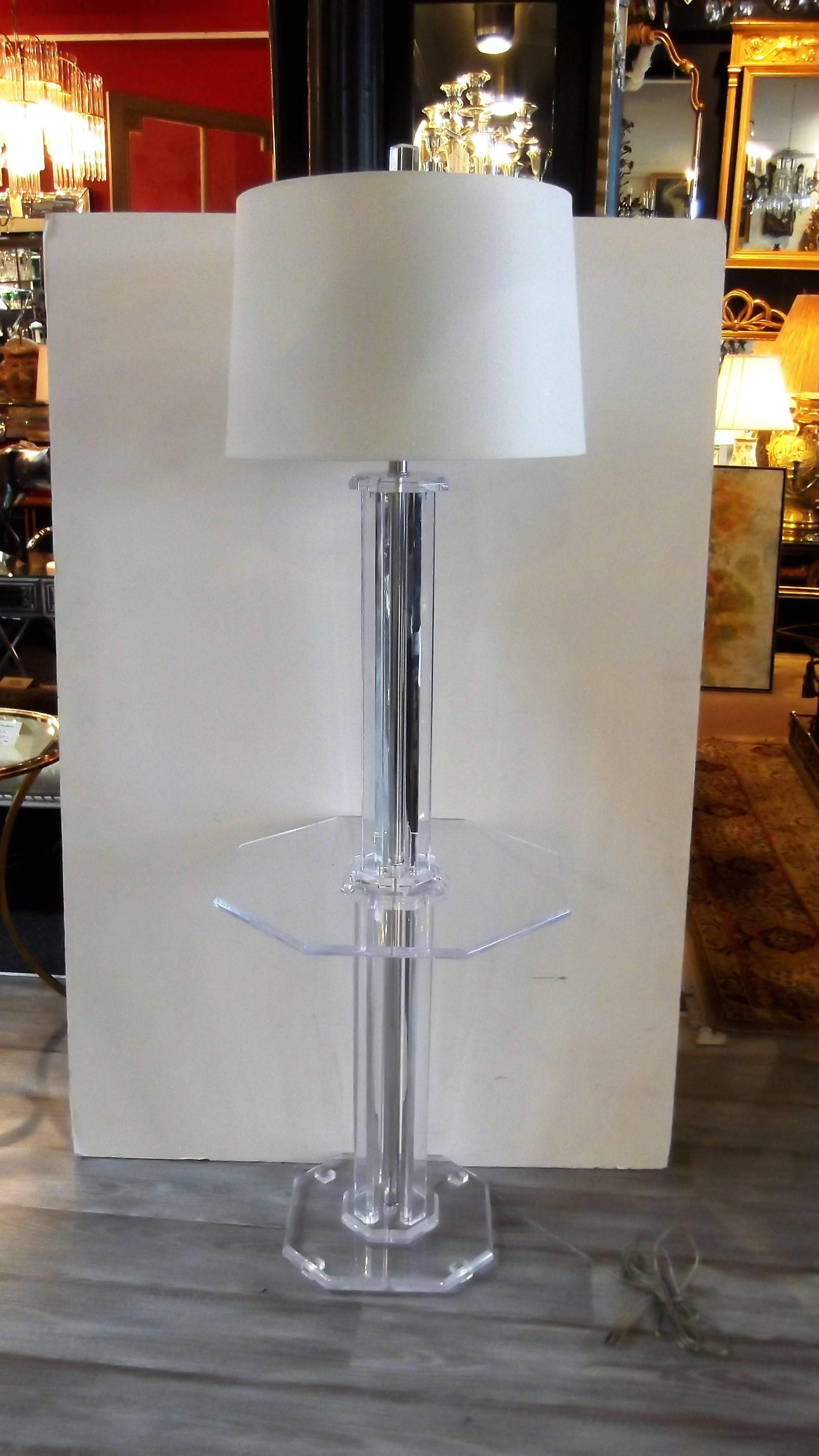 Mid-Century Lucite floor lamp with shelf. Classic 1970s Lucite in very good condition. The four part column center with octagonal table shelf supported by a square base with clipped corners. The shade is for photographic purposes only, not included.