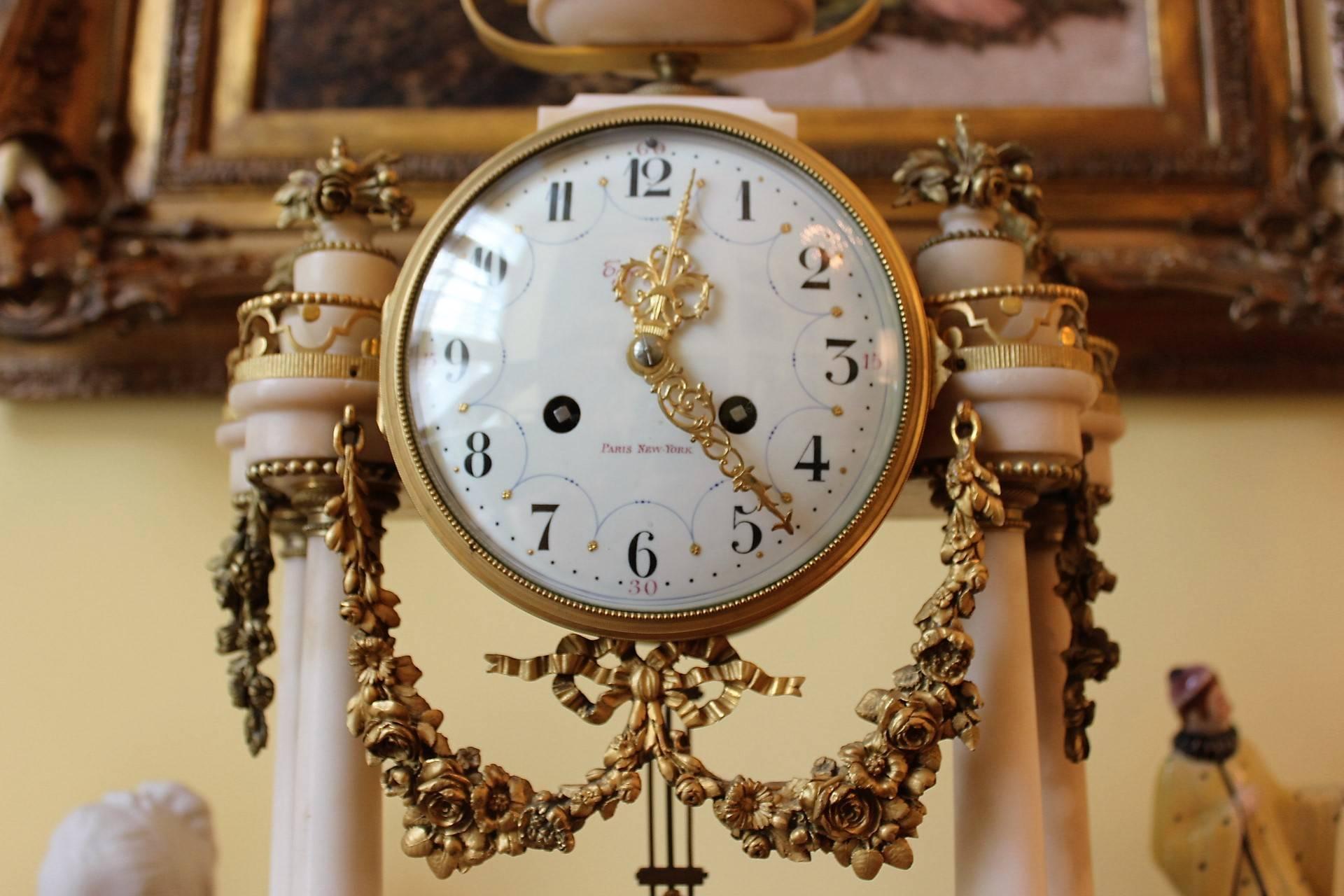 Stunning white marble and ormolu-mounted clock marked Tiffany on the hand-painted porcelain dial. Clock strikes on the hour and half hour. Louis XV Style case with French works, recently cleaned and serviced. All clocks might need adjustment after