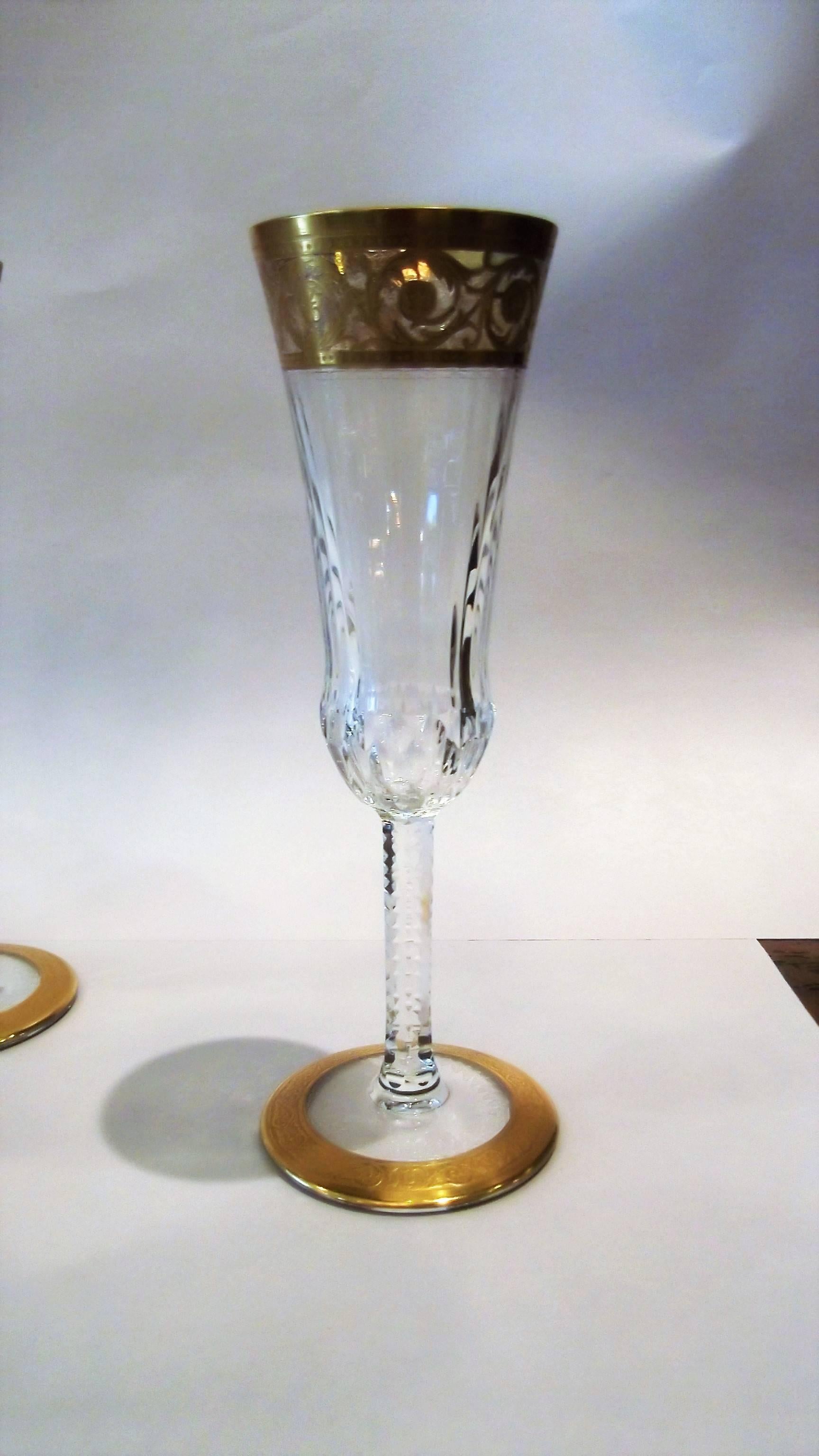 A set of 12 Saint Louis France fluted champagne glasses. Elegant scrolled gold details with gently fluted bodies and notched stems. This pattern is a Classic for one of the best glass makers in Europe. 

The thistle was the original inspiration