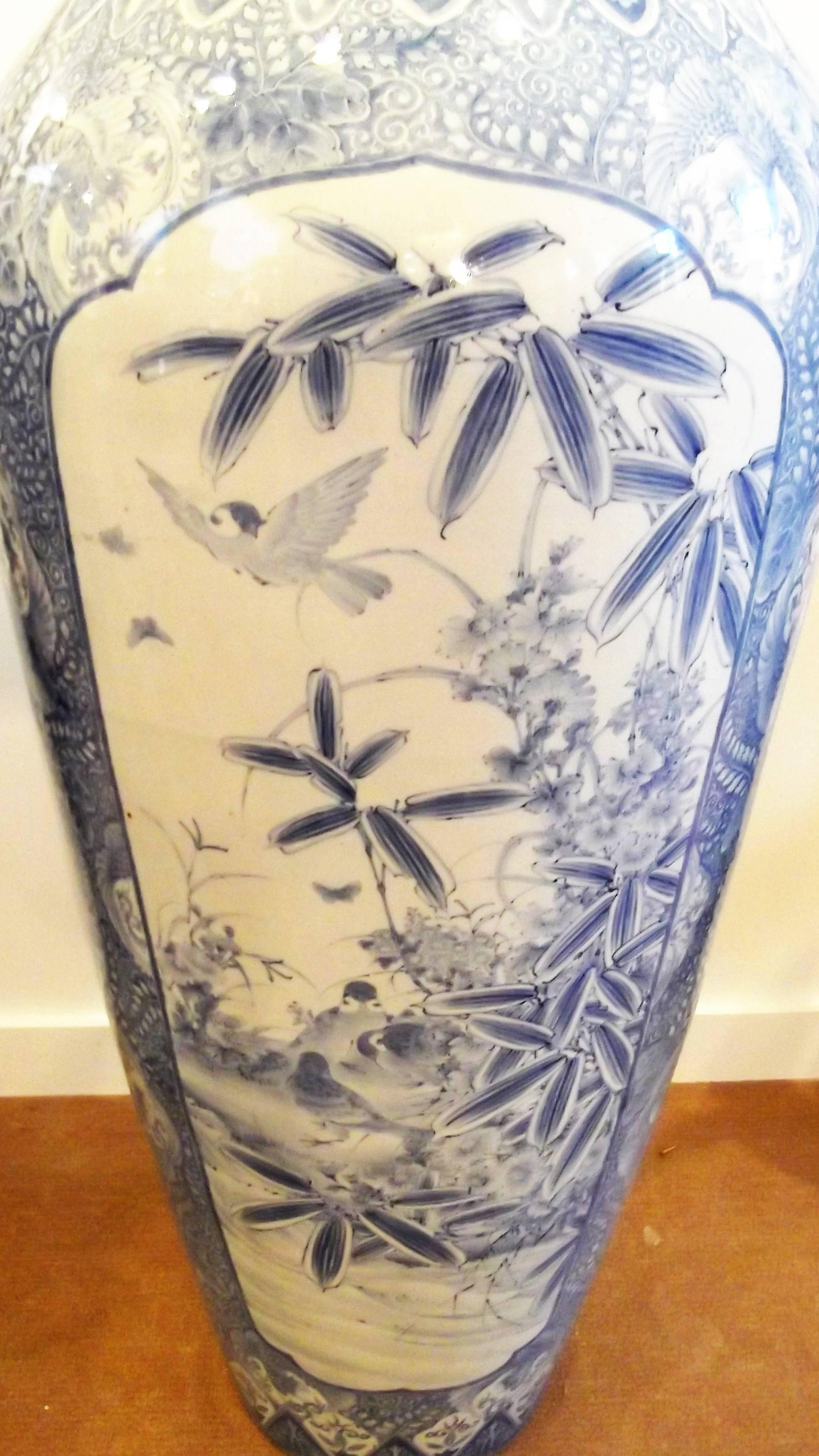Beautify decorated Japanese blue and white Imari porcelain palace vase. Of typical form with hand painted birds, flowers and bamboo plants. The vase has three large cartouches on the sides separated by classic Japanese embellishments. There is a