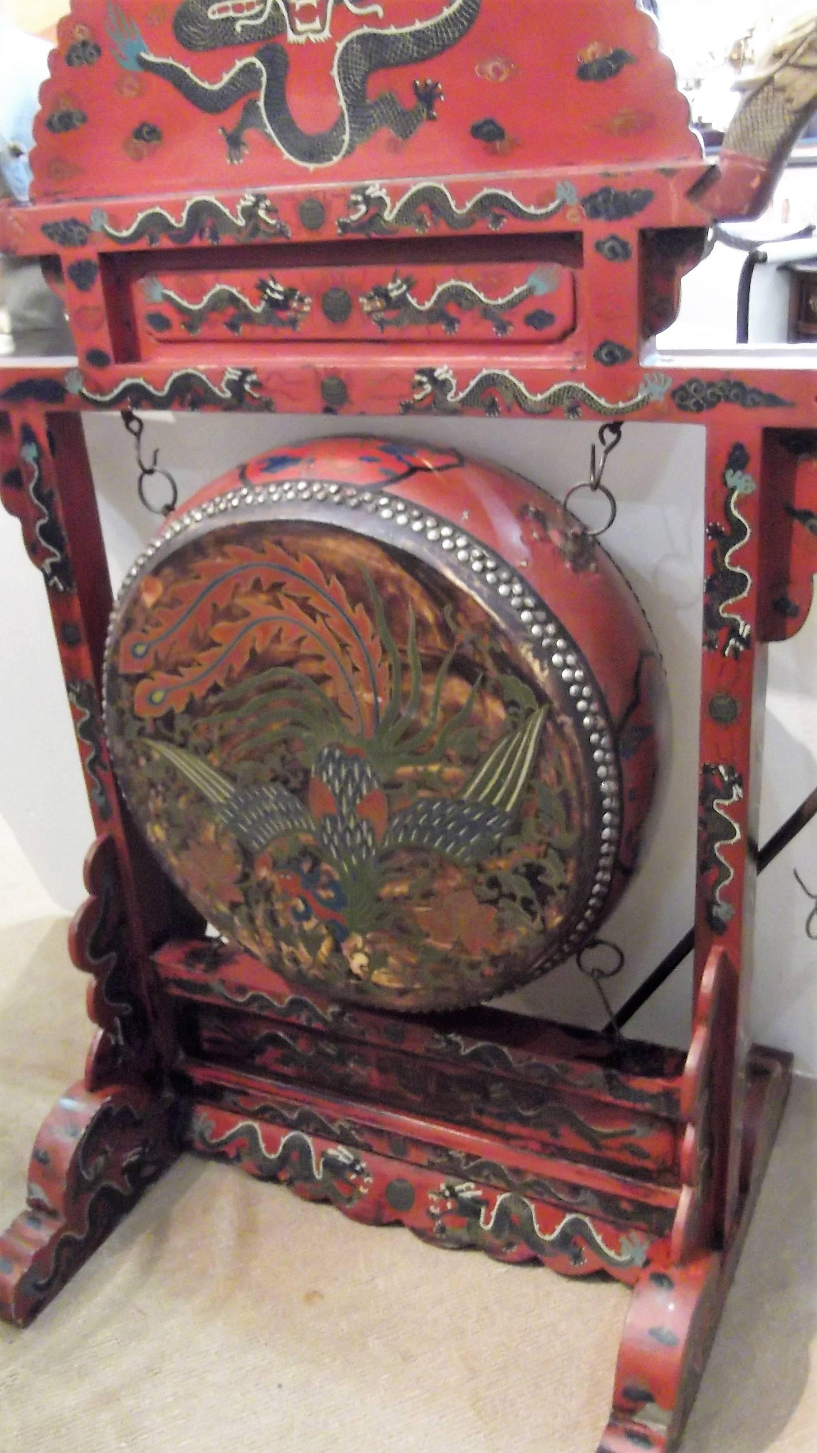Hand-painted antique Chinese temple gong in very good condition consistent with age. The gong is painted with bird of paradise, dragons and other Chinese design on a red background. Fully decorated on both sides, complete with gong hammer. The drum
