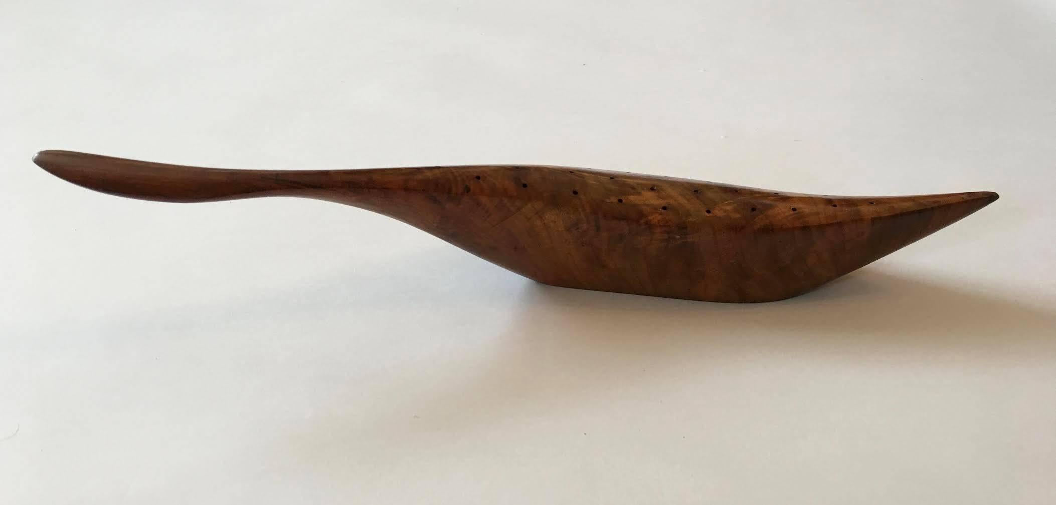 Hand-carved American walnut stylized bird by Emil Milan (1922-1985), circa 1950s and made in his studio in New Jersey.
This piece features superb shape, grain and color with 47 holes for serving hors d’oeuvre.

Base incised with Emilan mark and
