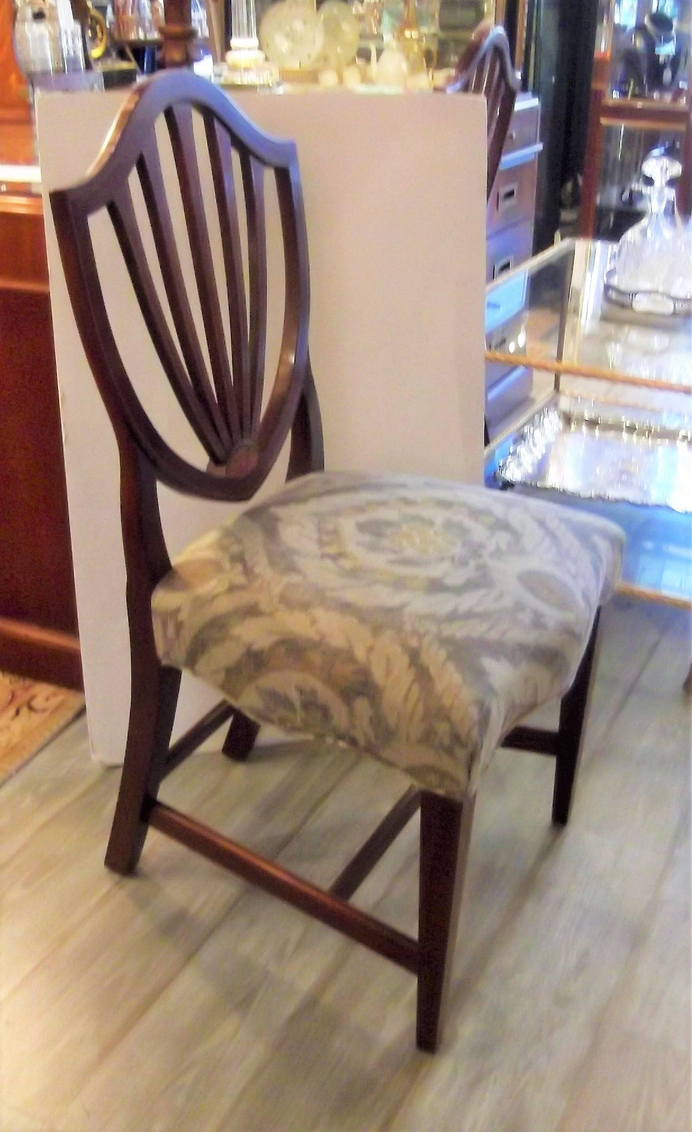Mahogany with satinwood inlay shield back dining chairs. Classic Hepplewhite style with delicate inlay on the backs and front legs. New taupe, smokey gray and yellow fabric for the seats in a traditional pattern.