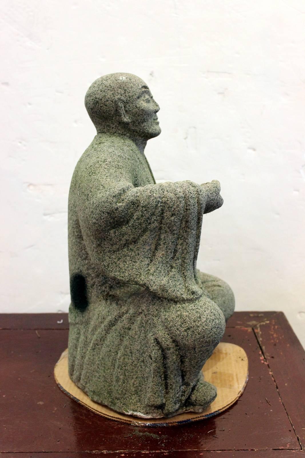 Japanese carved stone (possible Granite) sculpture of a monk from the late 18th to early 19th century. The surface is slightly worn slightly more textured than a honed finish.
