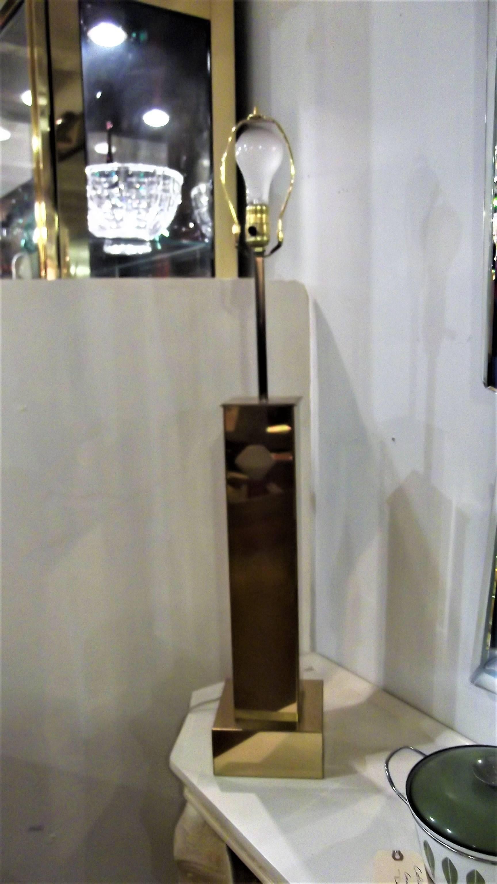 A brass square column lamp designed by Curtis Jere. The brass skyscraper style body in original condition with minor scuffs on edges. Signed.