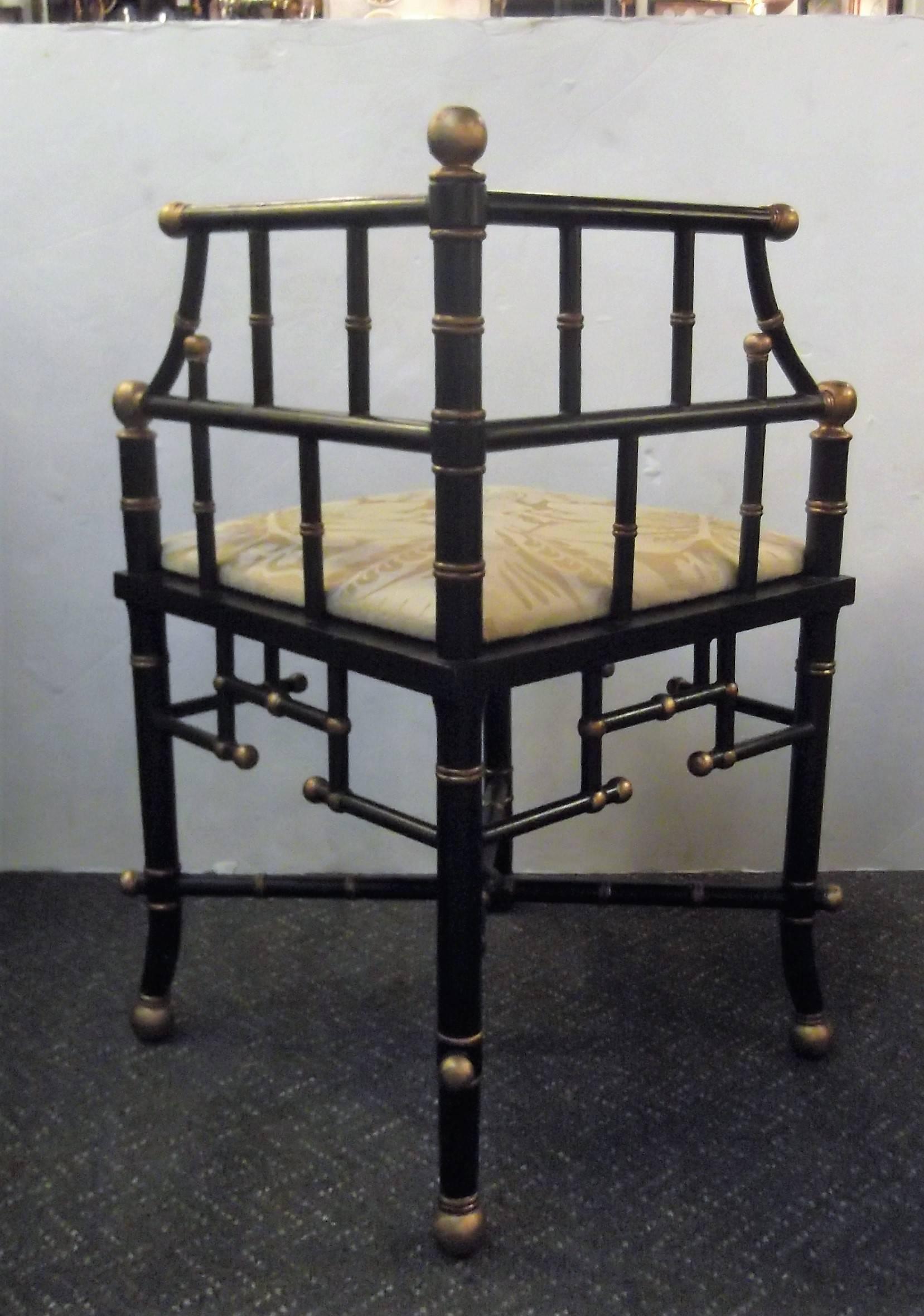 Charming black and gold corner chair with pale yellow damask seat. The stick and ball design with sloping arms and stepped apron along the bottom. This is a high Victorian style popular in the 19th century, this is a later 20th century model.