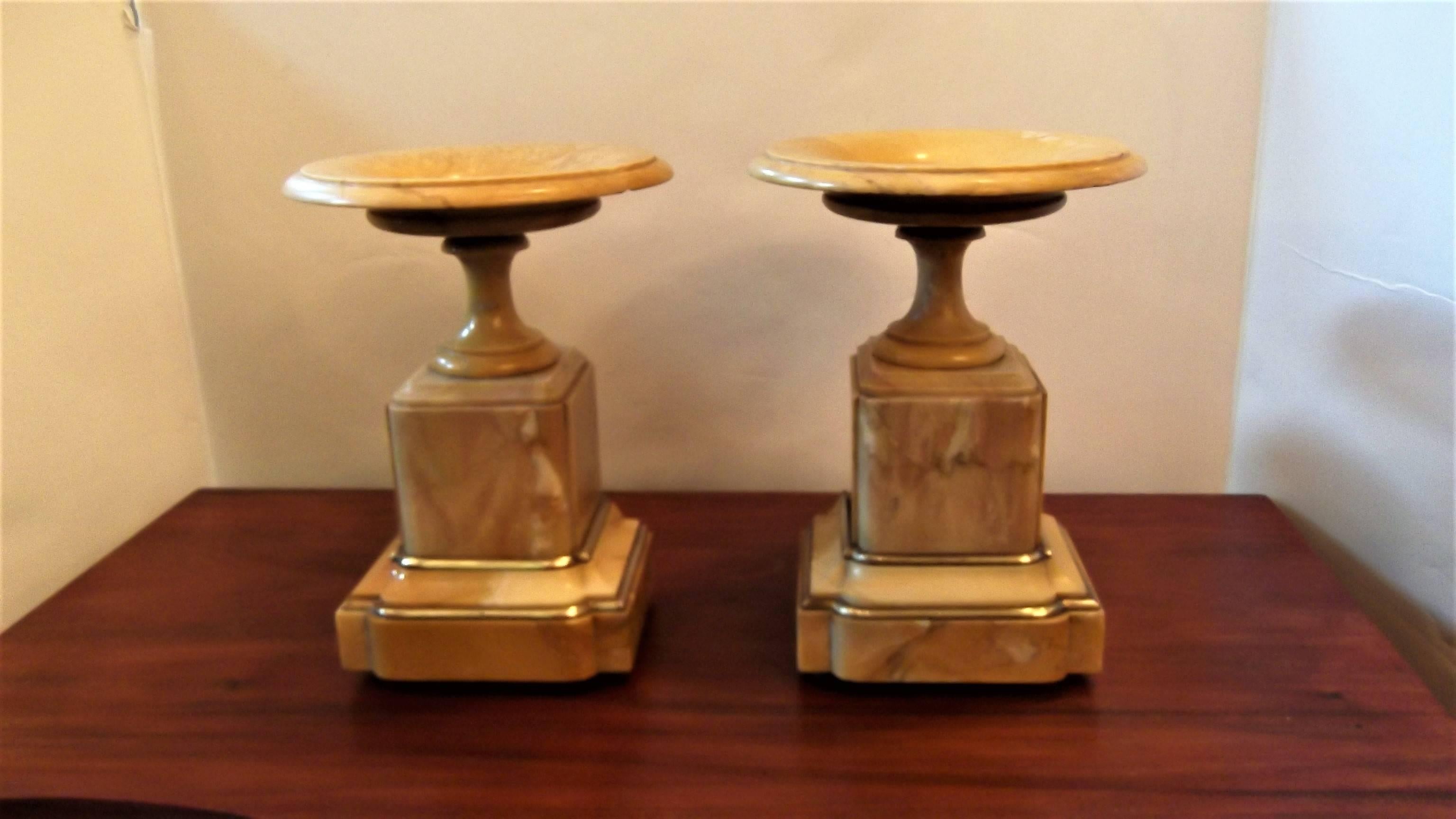 A pair of neoclassic sienna marble tazzas with burnished bronze mounts. The dish top with bronze centre resting on a stepped plinth base with bronze detail.