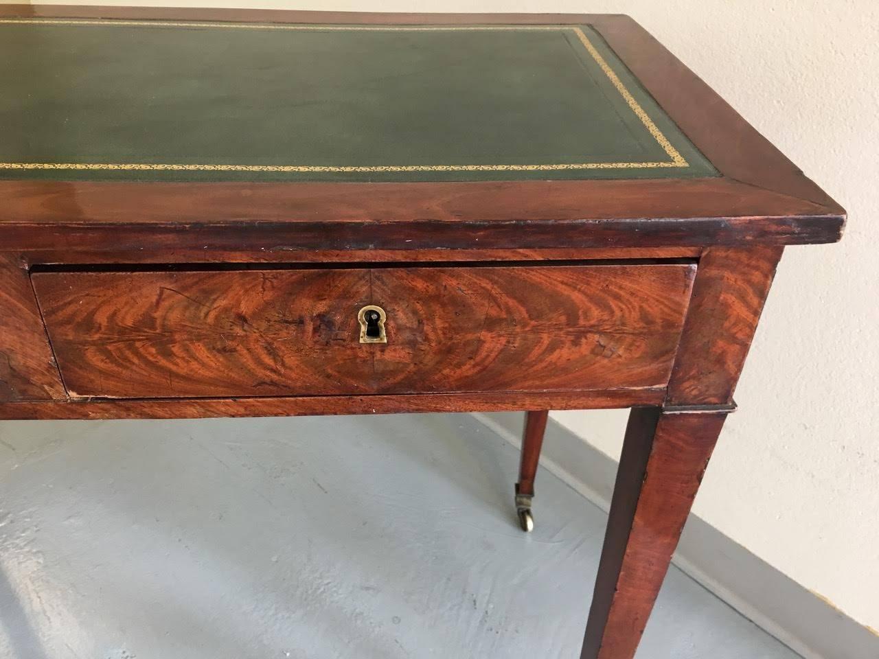 Description exceptional writing table made in England Circa 1820
Flame crotch mahogany with hunter green leather top and brass feet. Mitered top corners and two drawers. 
High gloss French polish finish.
No Key 

Dimensions; 38.5 inch length, 19.5