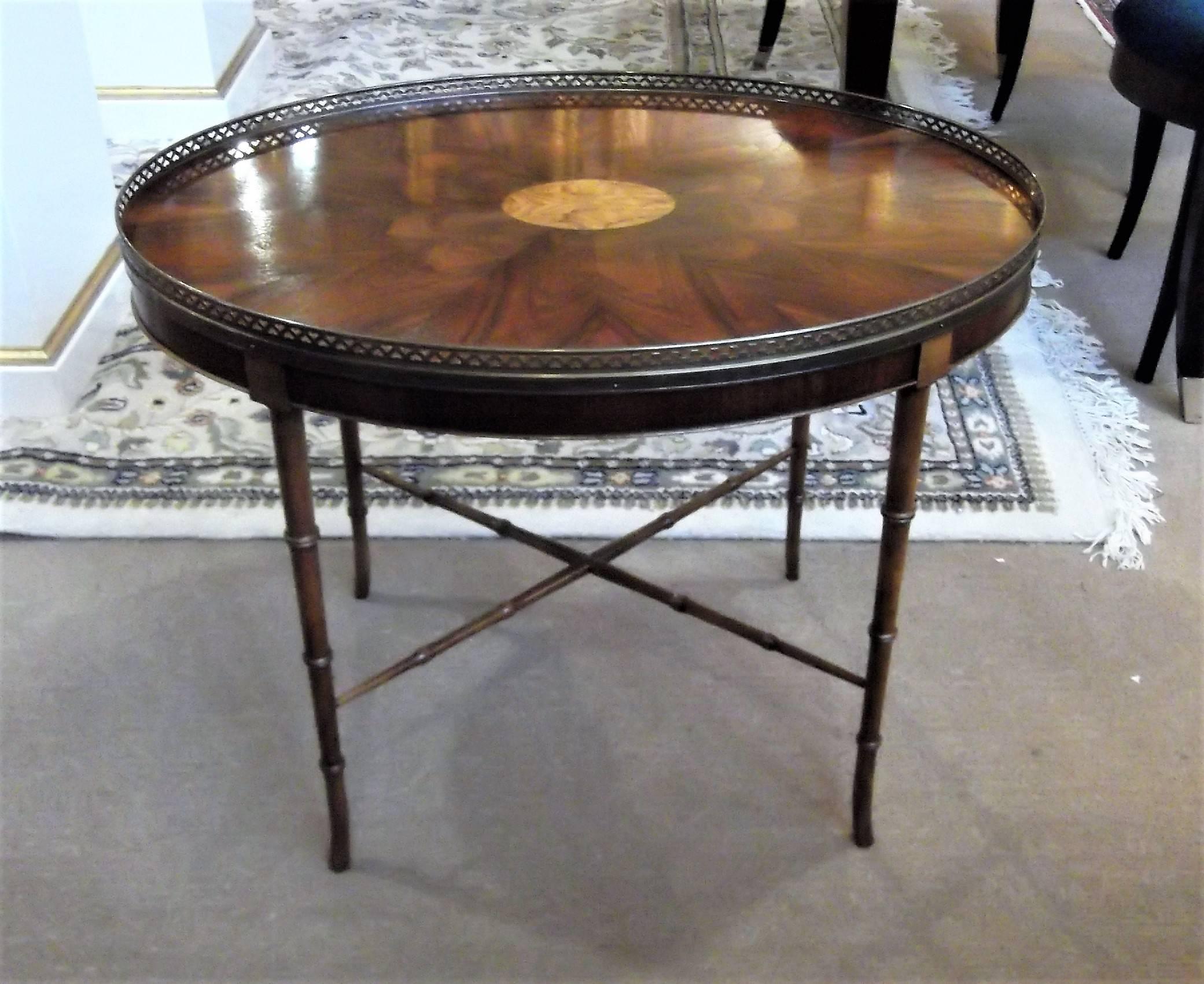 Beautiful flame mahogany Regency style brass gallery edge table. The top is beautifully finished in a matched wood pattern with a center inlaid medallion. The table is a slightly higher than a typical coffee table following the traditional height of