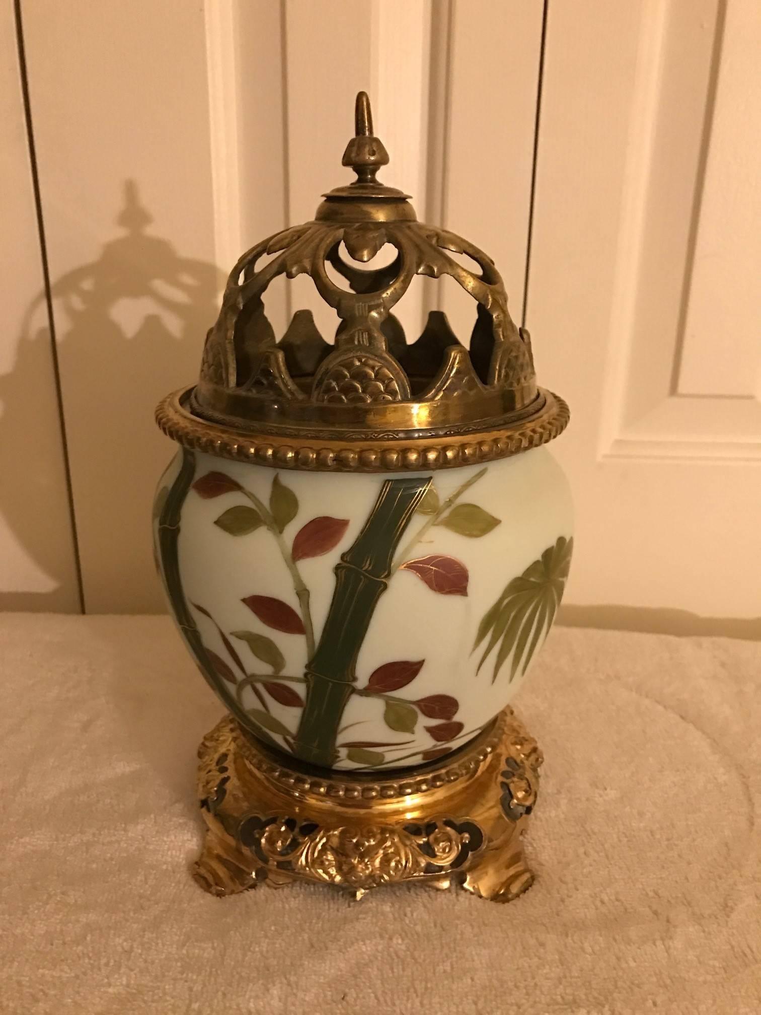 A hand-painted porcelain urn with pierced cast brass lid. The tropical motif pattern is all hand decorated with gilt brass base. The quality and detail of the porcelain is in the manner of Royal Worcester. This would be a beautiful jardinière if
