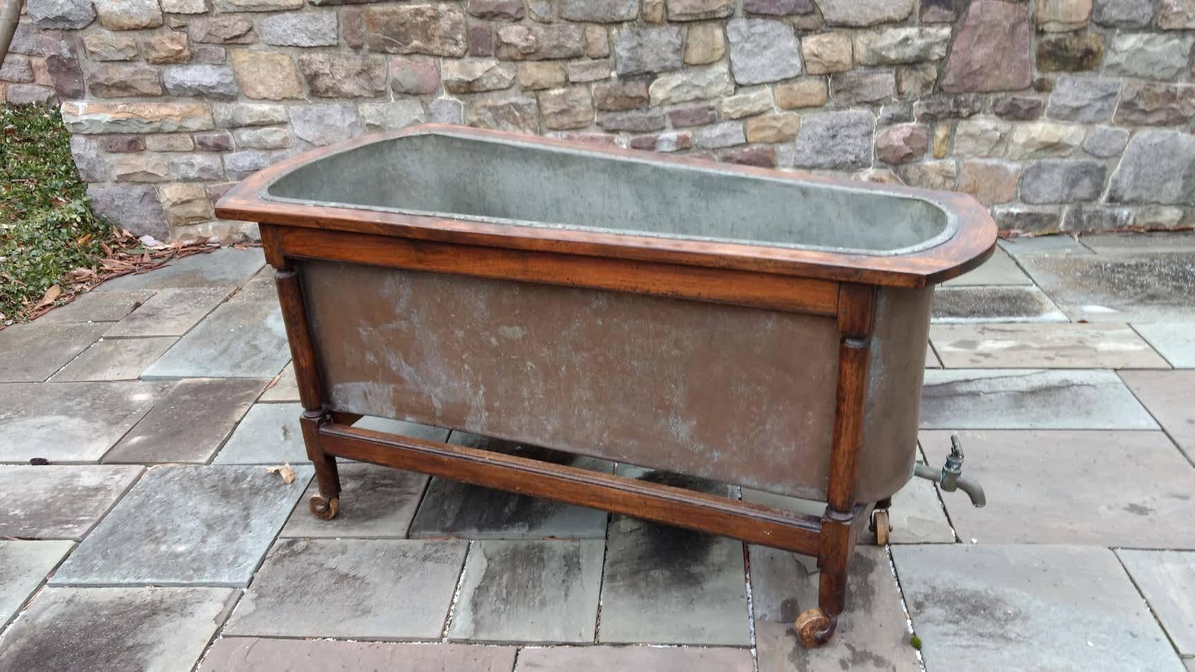A mid-19th century French copper bathtub with walnut frame. The copper is tin or zinc lined and shows all original patination. Some repairs to the seams shows this has been well cared for more than a century. The depth of the tub interior is 19