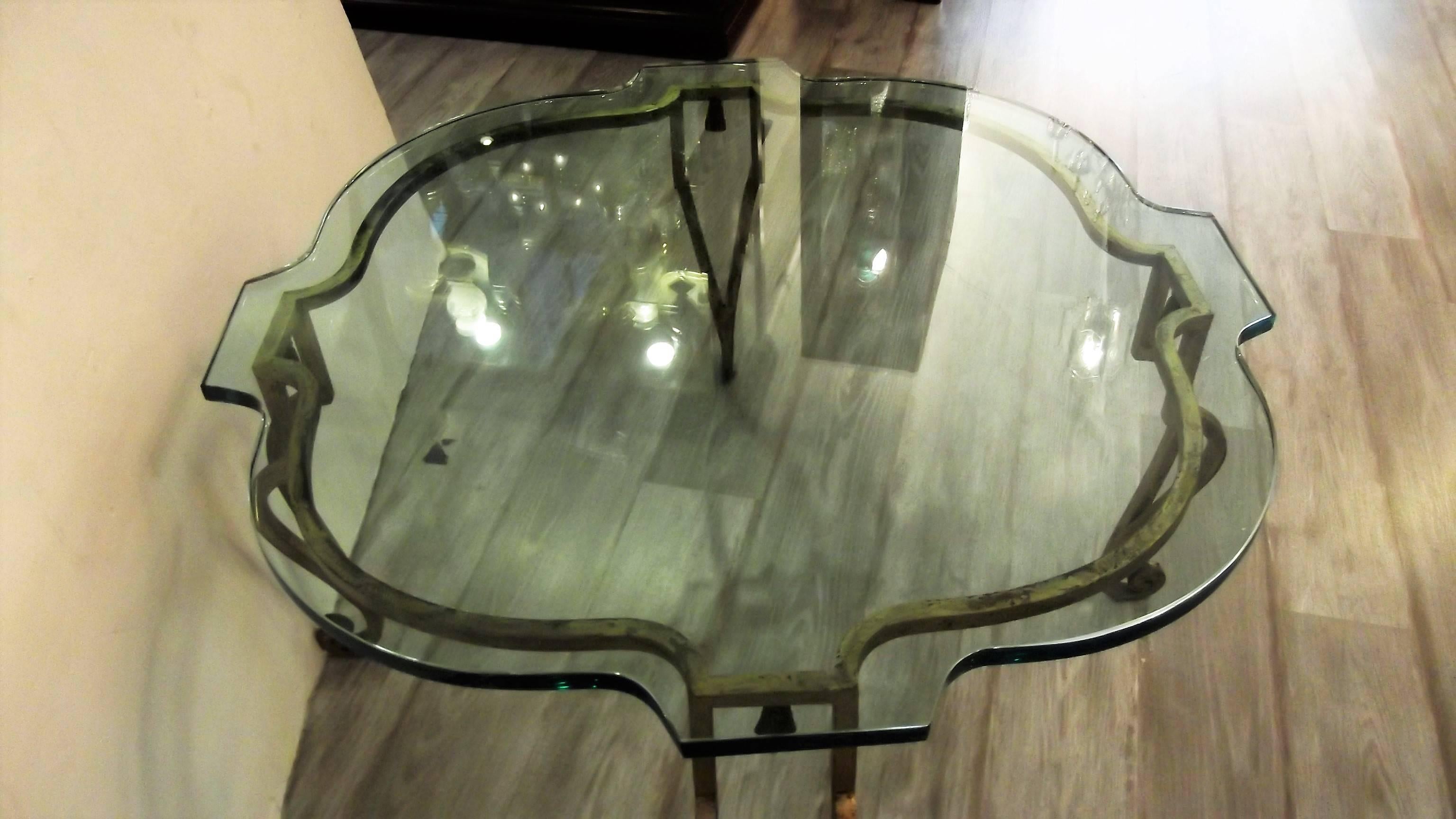 Elegant French glass and distressed gilt iron cocktail table attributed to Maison Ramsey. The custom scalloped top resting on a hand-forged shapely iron base with a worn gilt finished surface. Nice medium size with open and airy feel.
There are