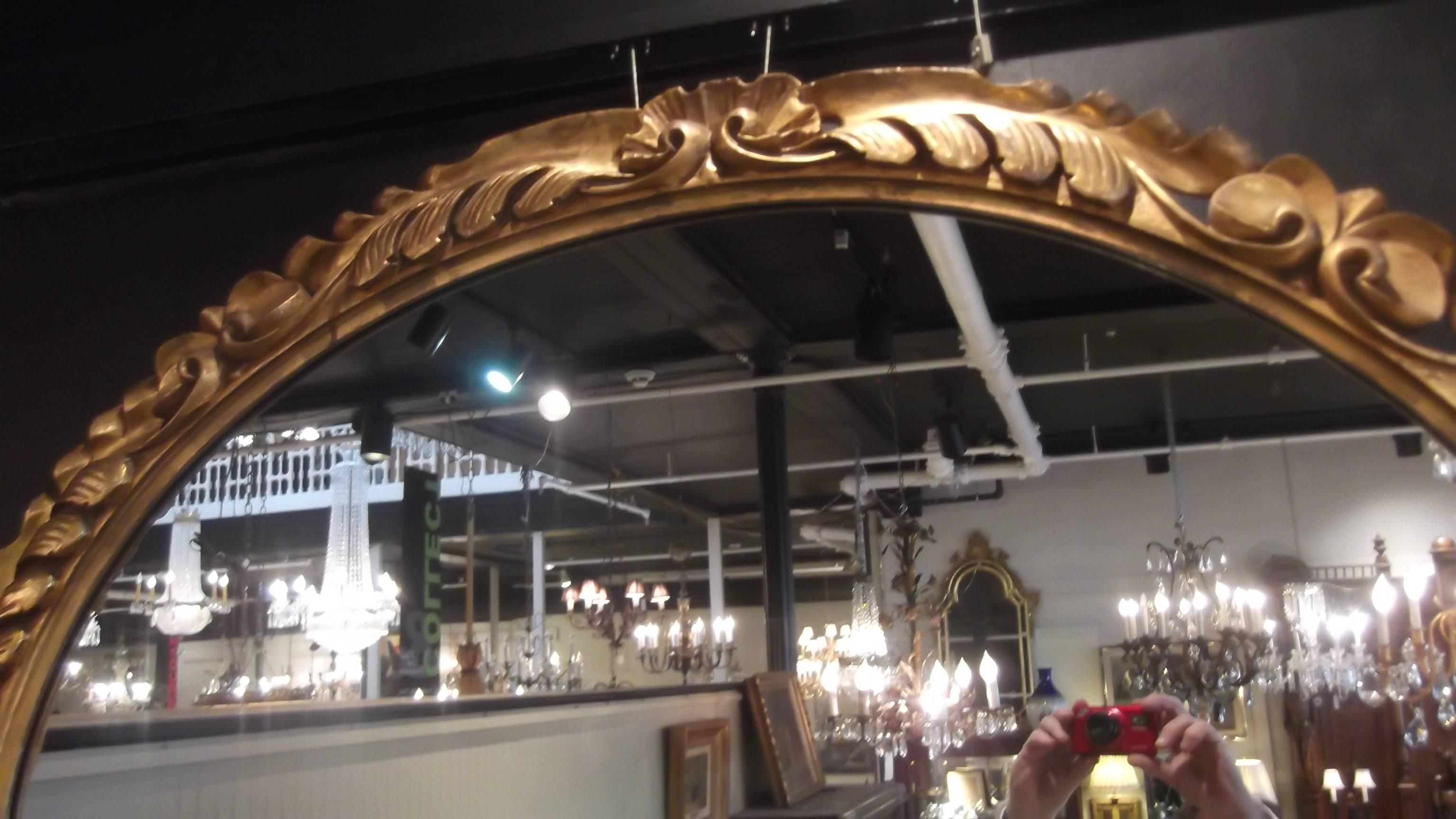 Deeply carved giltwood oval wall mirror, Italian. This mirror can be hung as portrait or landscape. The nicely detailed frame is decorated with scrolling and shell motif, the silvering on the mirror is very clean.