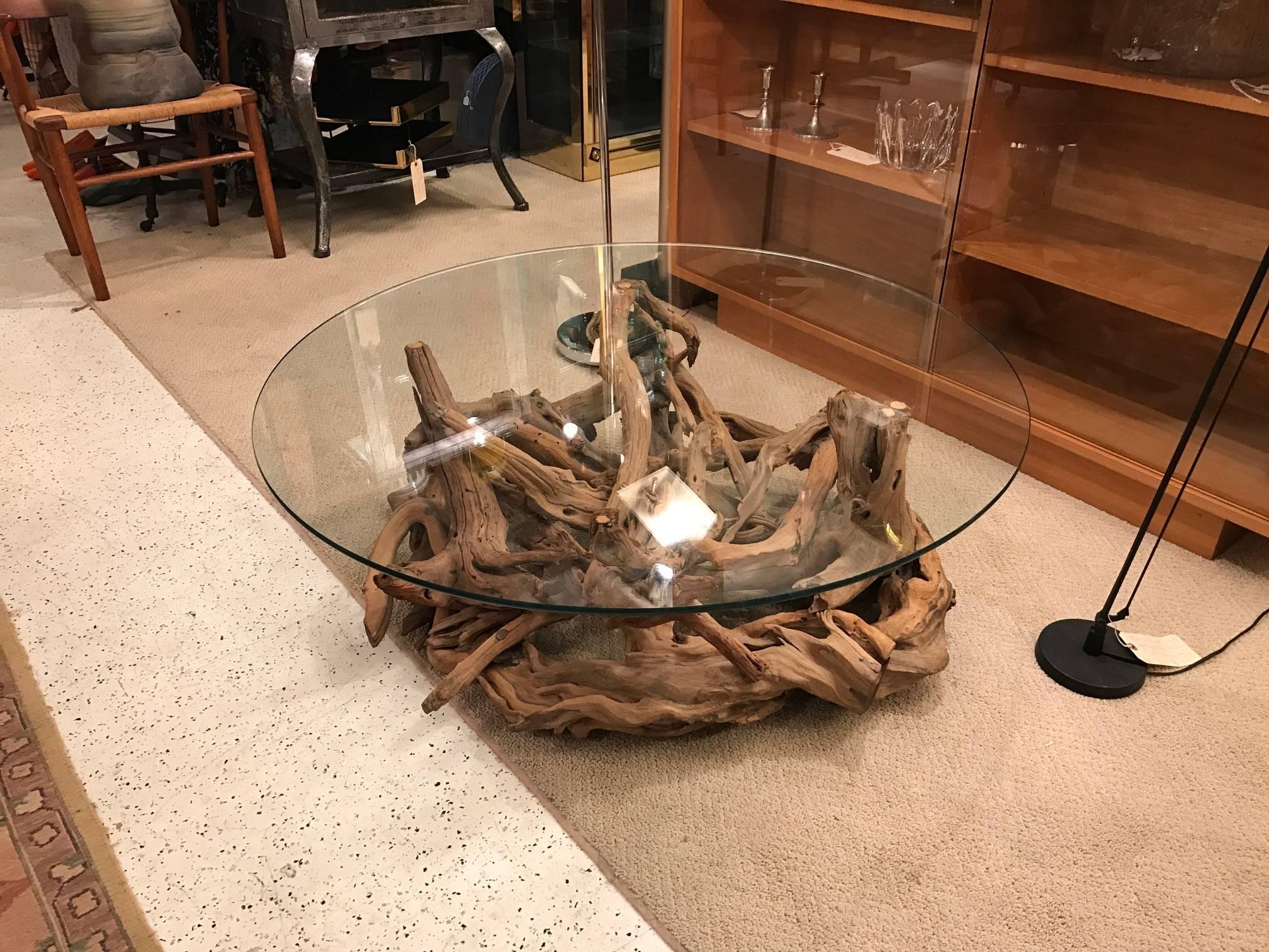 Stunning large driftwood coffee table with round tempered glass top. The authentic driftwood base in an overall circular design accompanied by a glass top base, Mid-Century Modern.