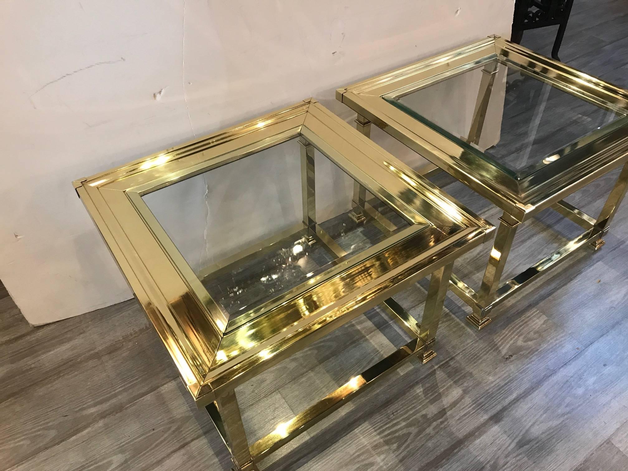 High style polished brass and glass square cocktail tables made by Mastercraft, circa 1970. The two tables are used together as bunching tables or separately. Versatile and sophisticated.