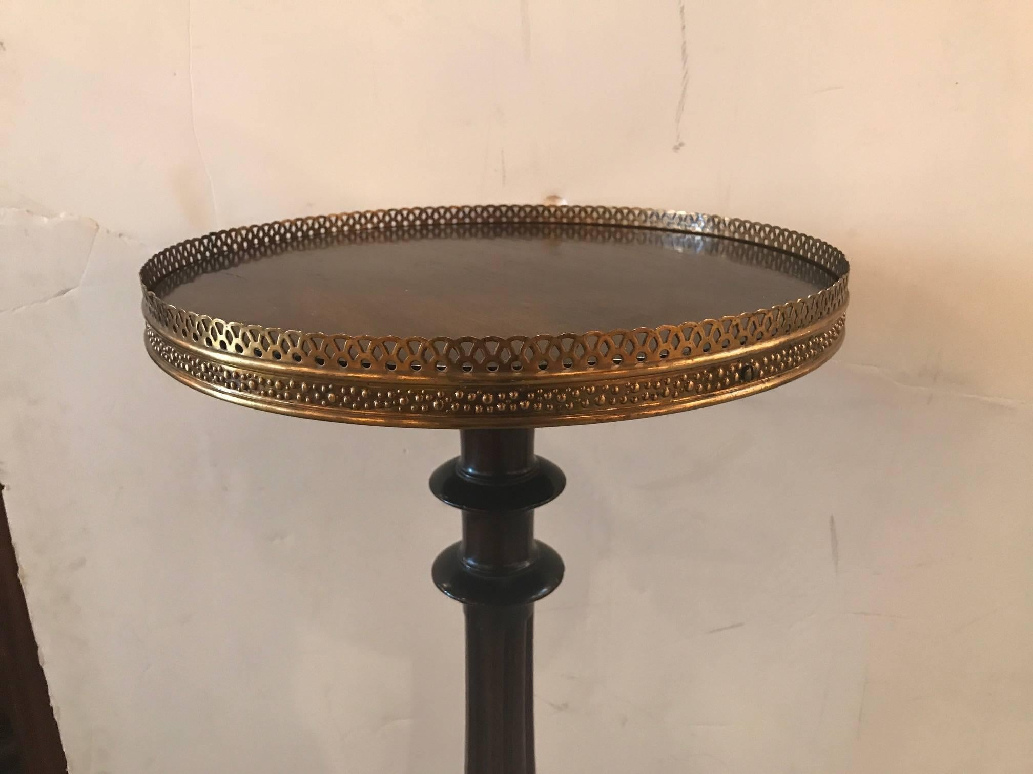 Tall mahogany pedestal fern table with pierced brass gallery edge. The shapely centre column resting on three pierced scrolling legs. Measure: The top is 14.25 inches in diameter.