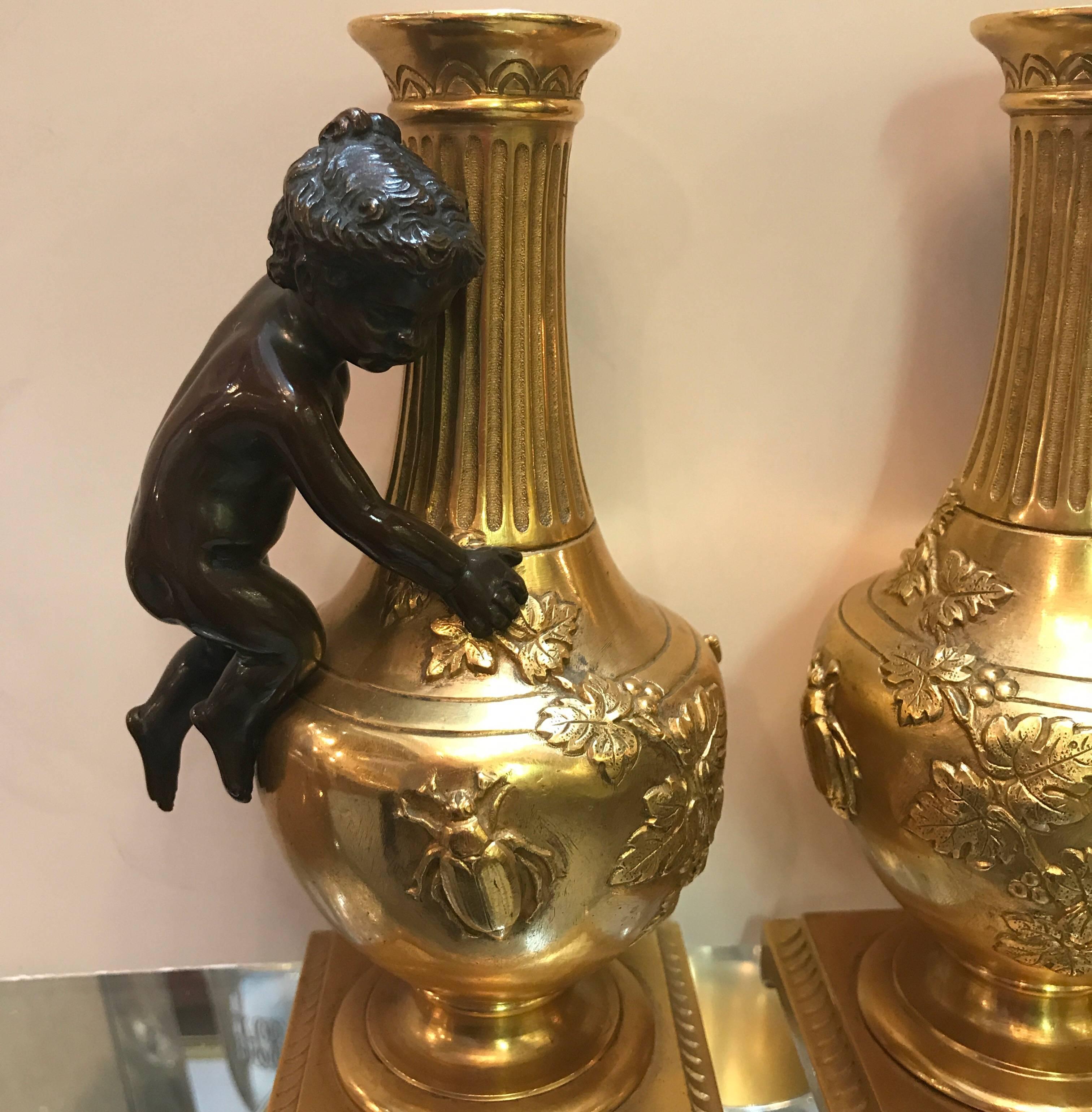 A pair of French bronze gilt urns. The urns with cast patinated putti handles. All original and in excellent condition, France, last quarter of the 19th century.