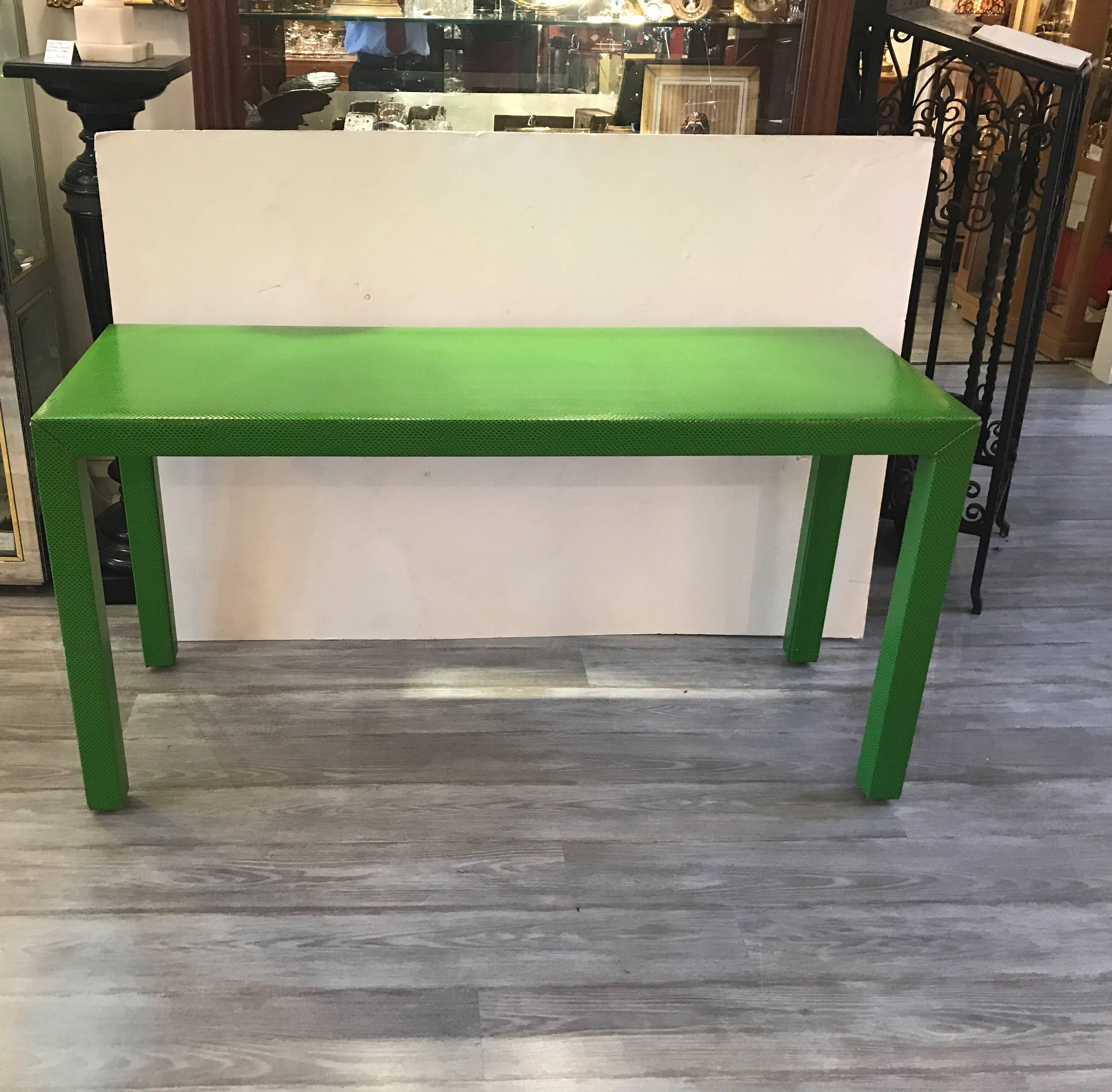 An iconic, 1970s Parsons console table in an unexpected vibrant green faux snakeskin covering.