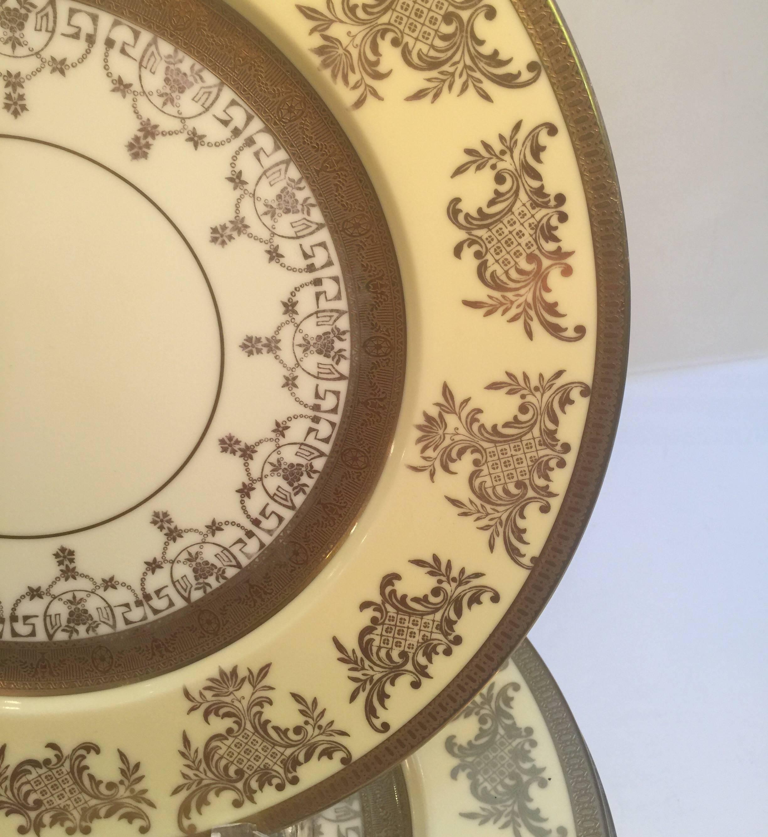 A set of 12 gilt service plates with lacy gilt borders. The gold is over a vanilla outer border with a thick gilt centre band. These plates are a full 11 inches in diameter, made in the USA, circa 1920.