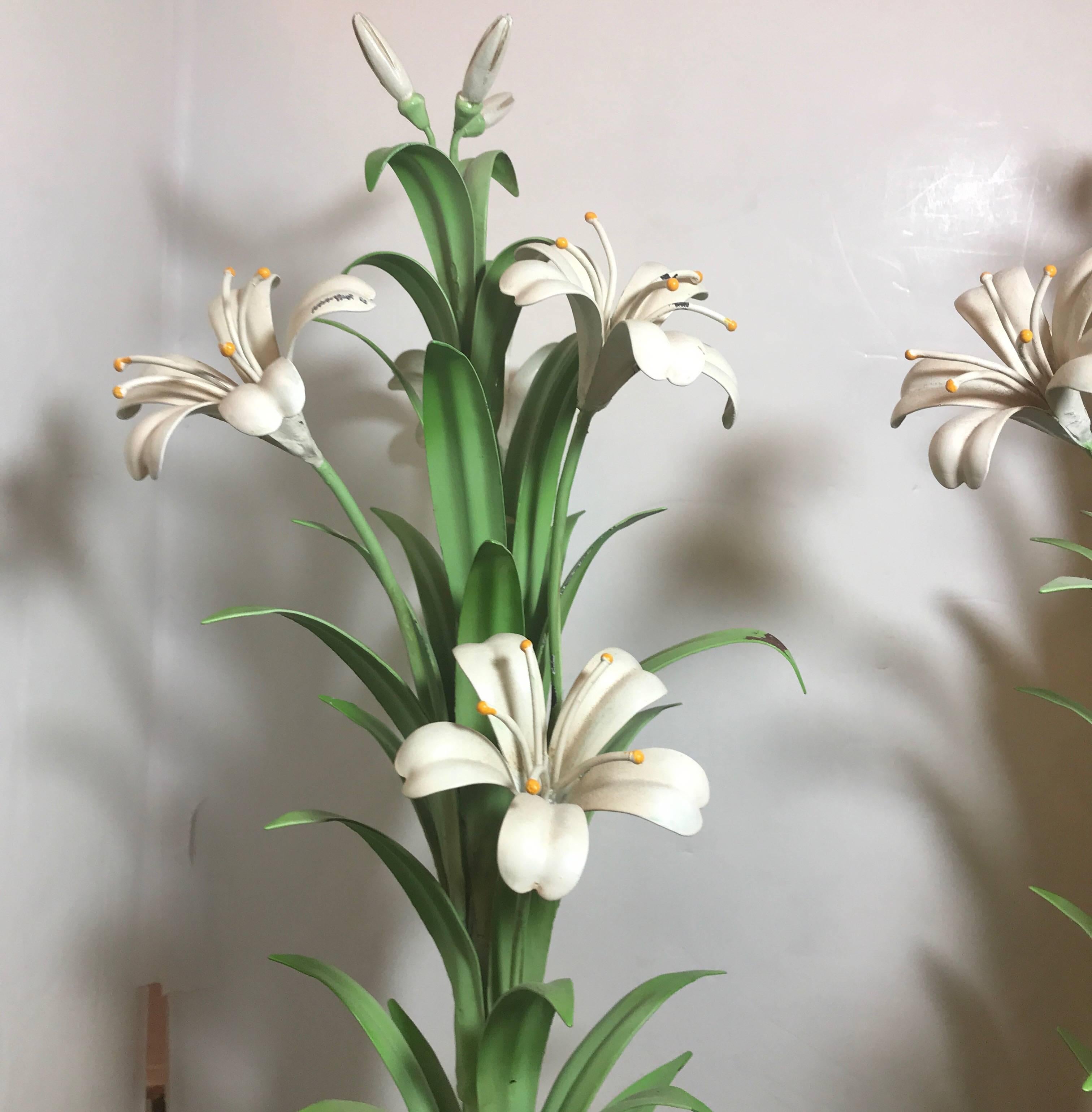 Beautifully hand-painted Italian tole ware urns with tall Madonna lilies. The handled urns with a black background with gilt highlights. These are narrow and perfect for a mantel piece, console table or sideboard, circa 1950s the bases are 4.5
