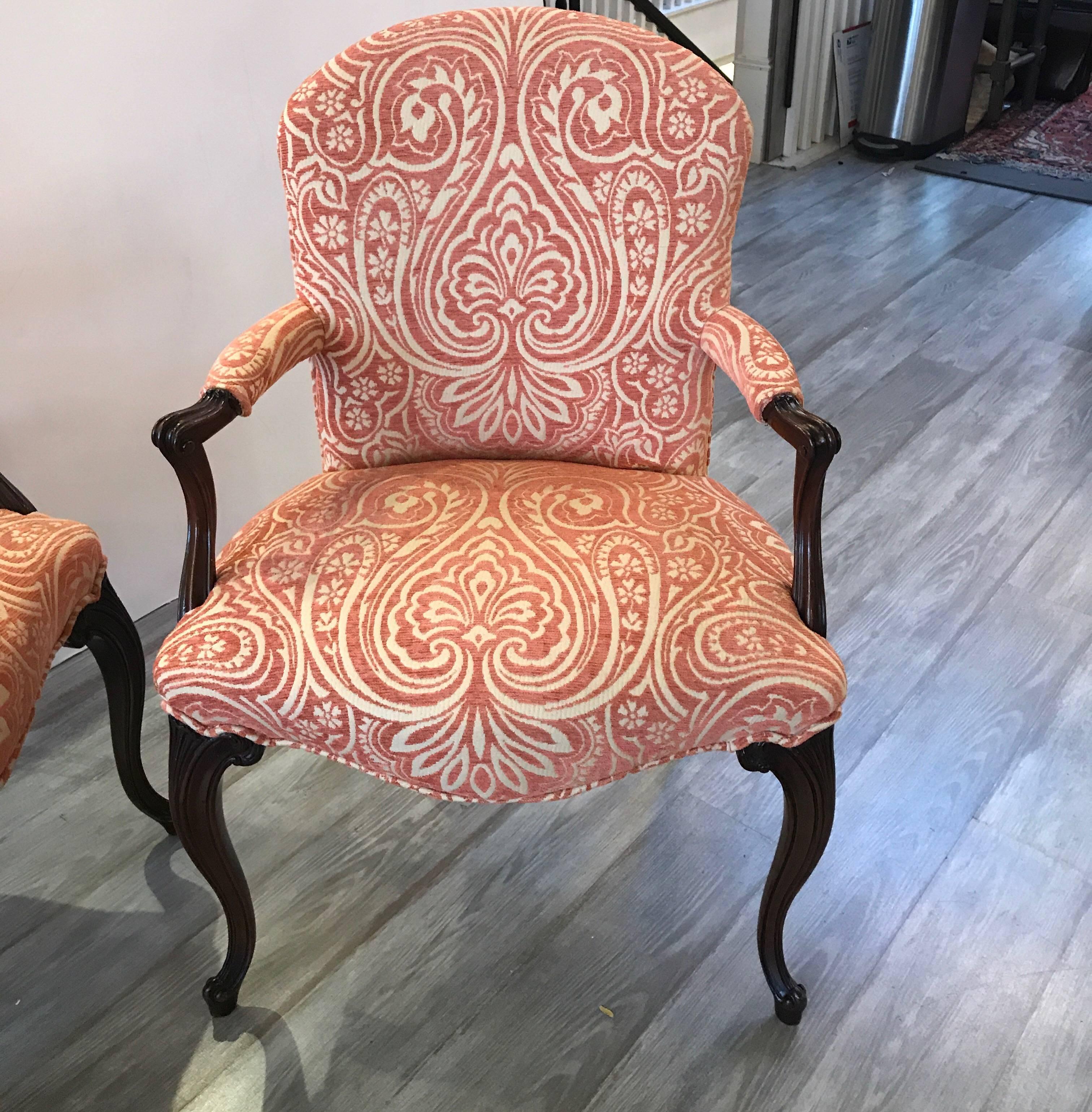 A shapely pair of hand-carved mahogany open armchairs with new chenille salmon upholstery. The graceful legs with carved knees and feet with carved arms. Quality eight way hand tied spring construction.
