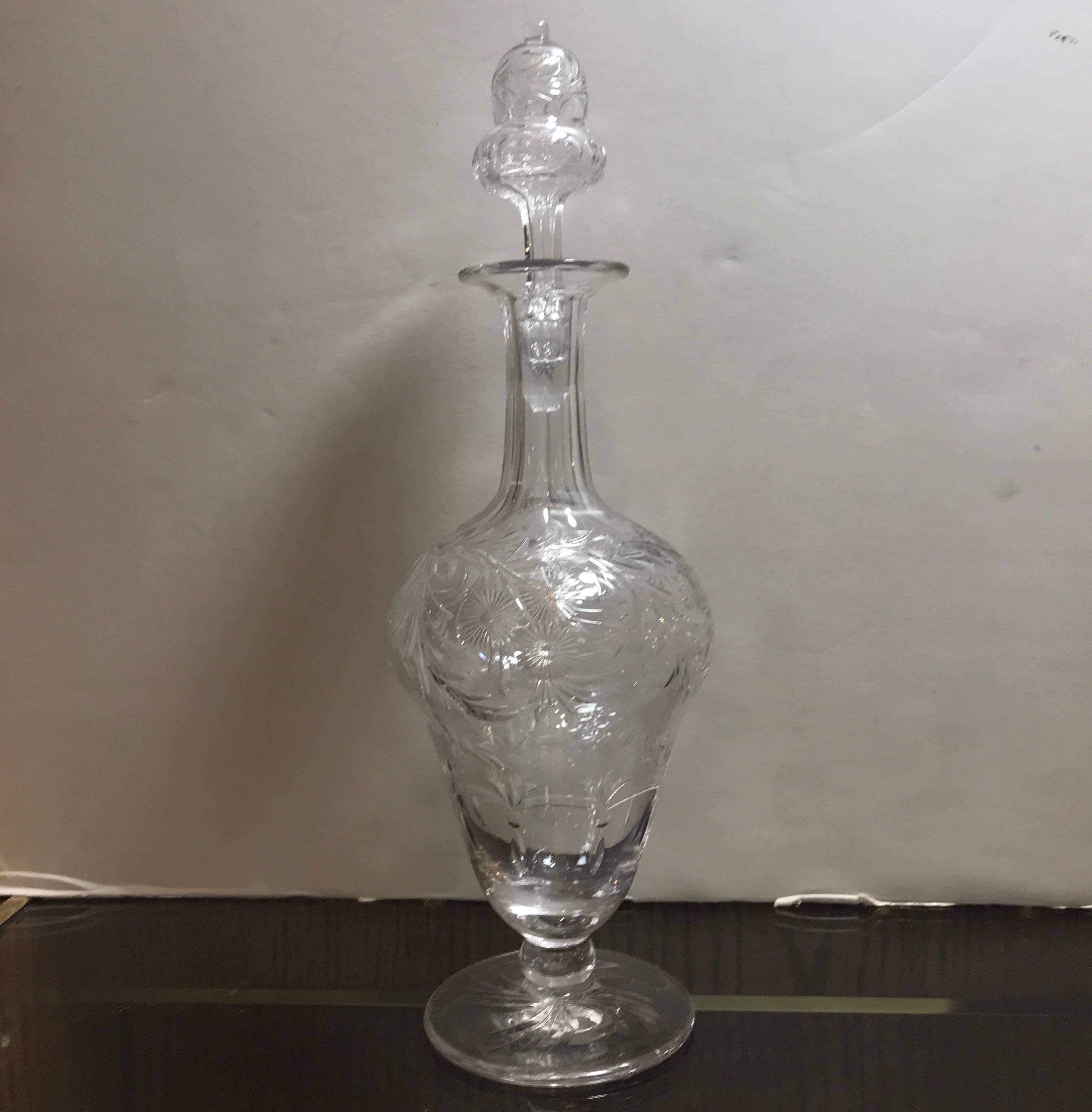 Elegant and diminutive pair of mouth blown and hand cut decanters by Hawkes. Each one with original stopper. The delicate all over vine leaf and floral decoration on the stoppers, body and pedestal base. These decanters of a smaller size are perfect