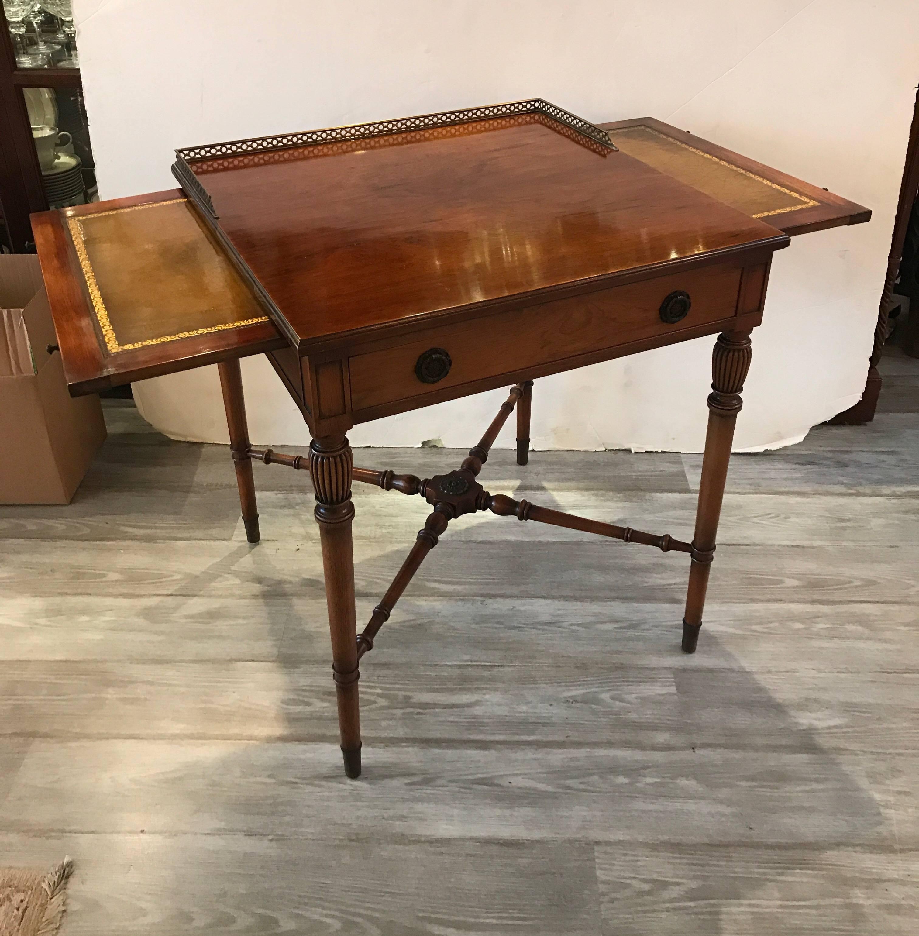 Graceful rosewood and mahogany square side table with brass pierced gallery edge. The drawer top with two side pull out trays with original olive leather and gilt tooled panels. The hand carved tapering legs with X stretcher base. This table is a