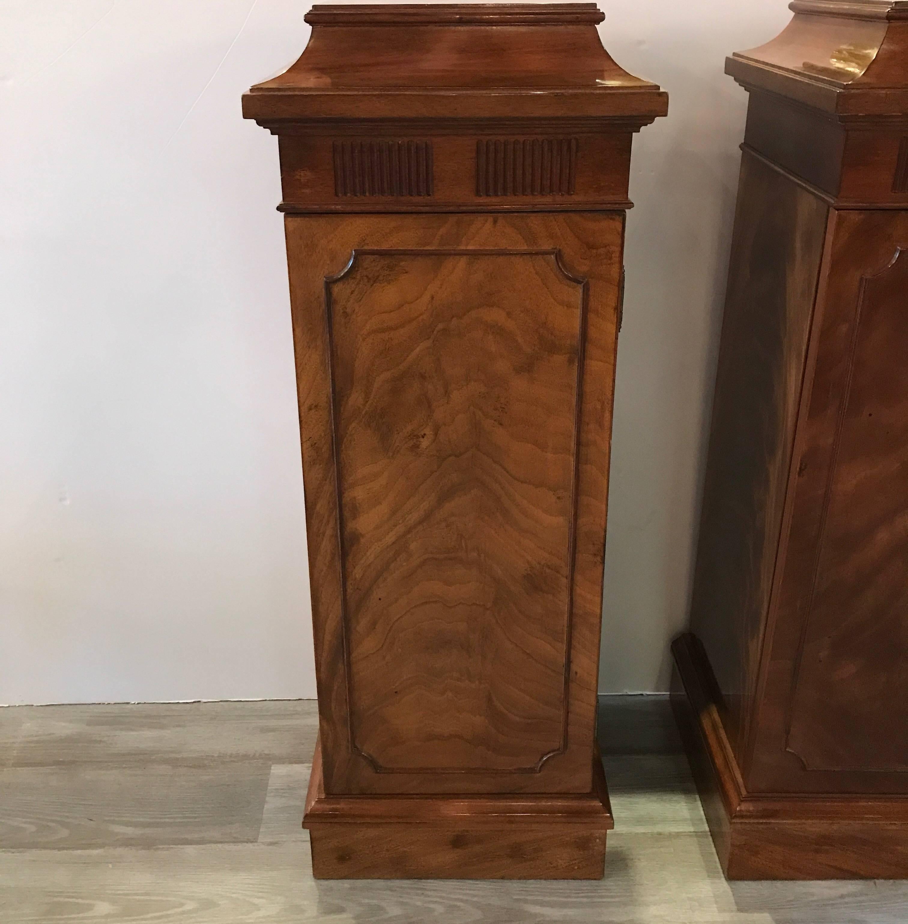 A fine pair of flame mahogany storage pedestals. The concealed front door opens to reveal a generous storage compartment. The tops with nicely caved and coffered detail. These are nice cabinetmaker pieces from circa 1950.